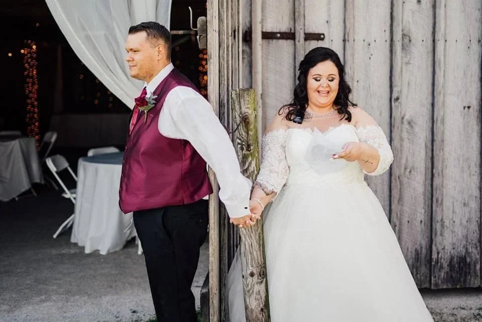 Bride and groom holding hands at the barn doors