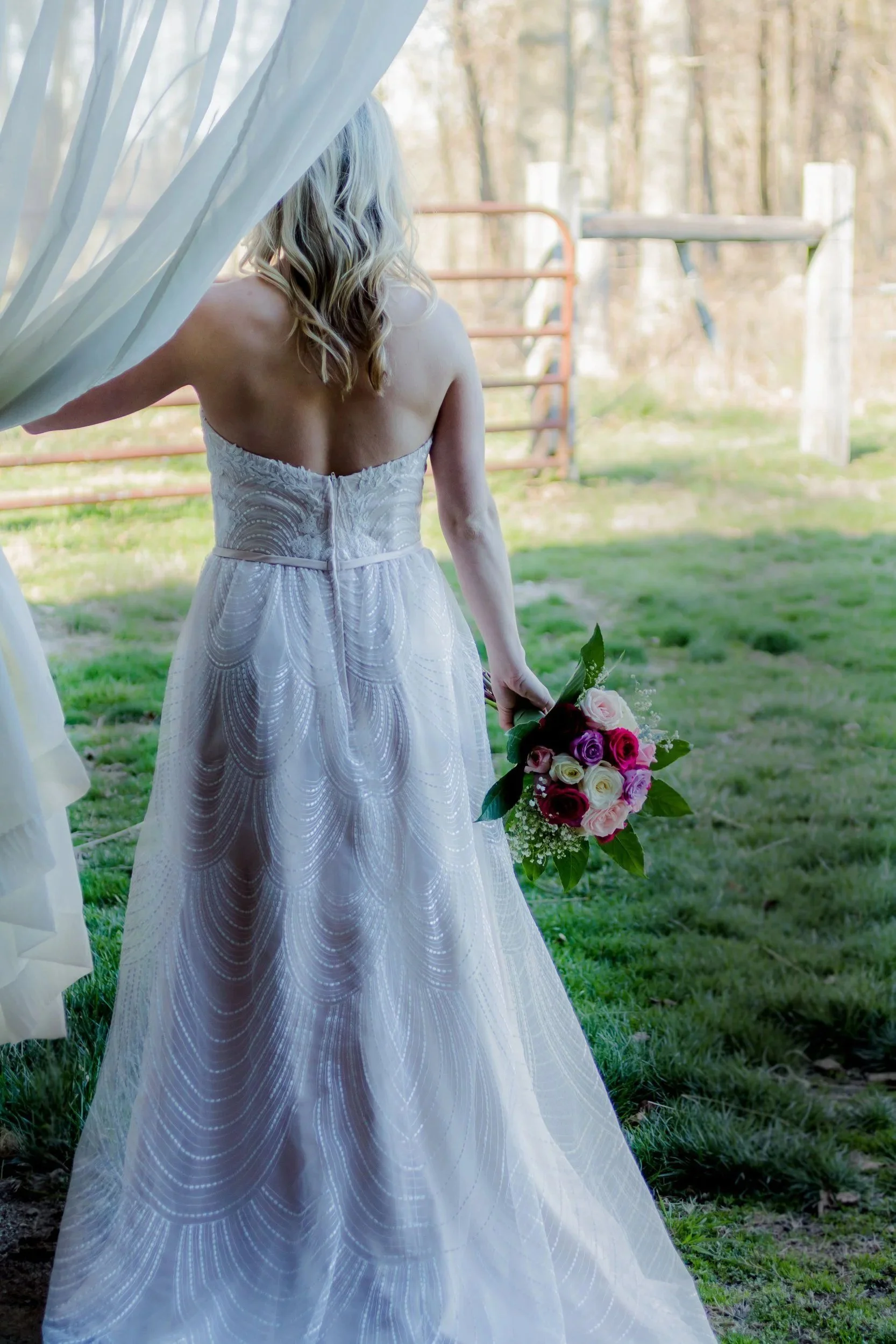 Bride in a strapless gown walking toward the paddock