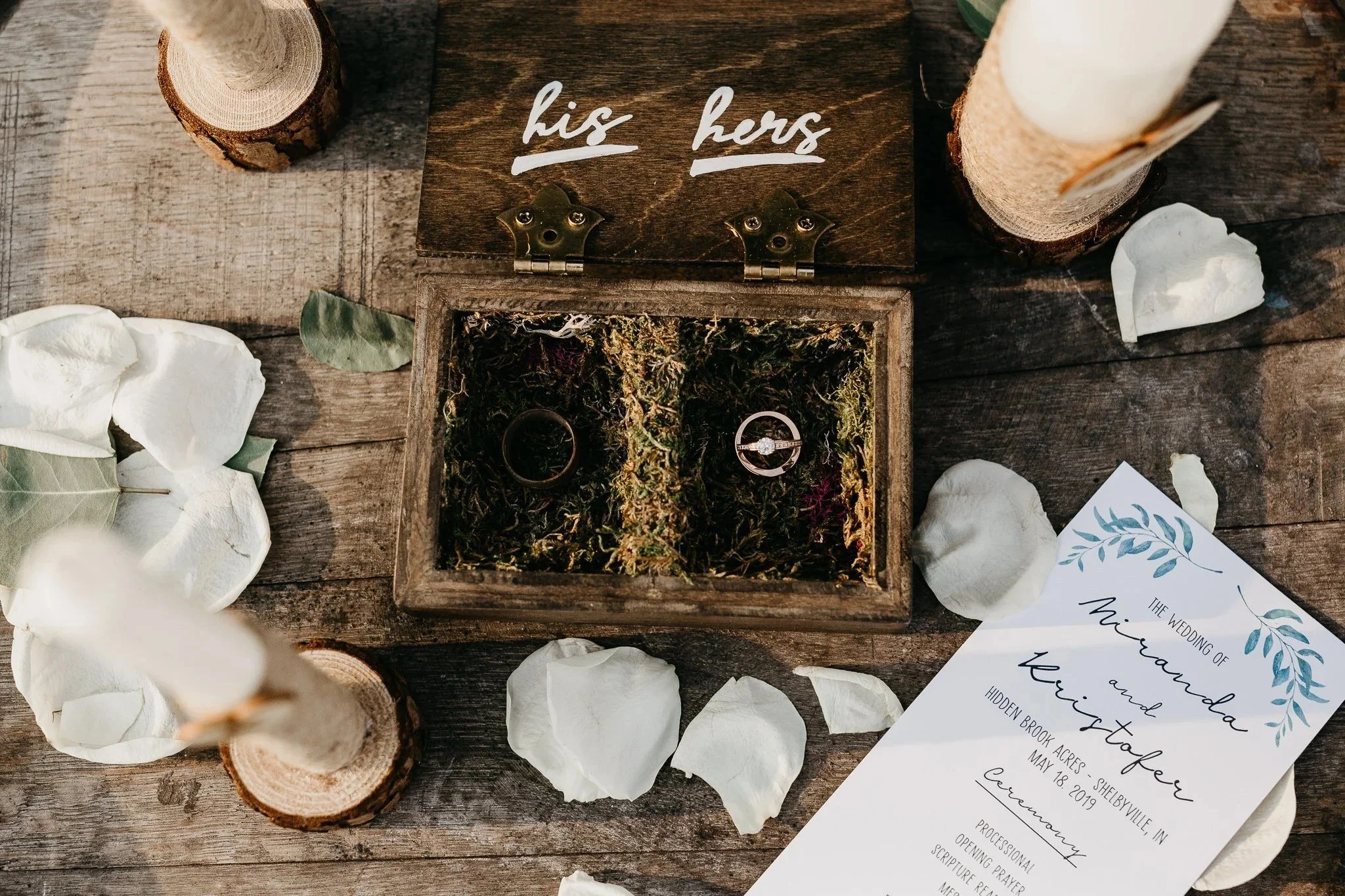 His and hers ring box and wedding details on a wooden table