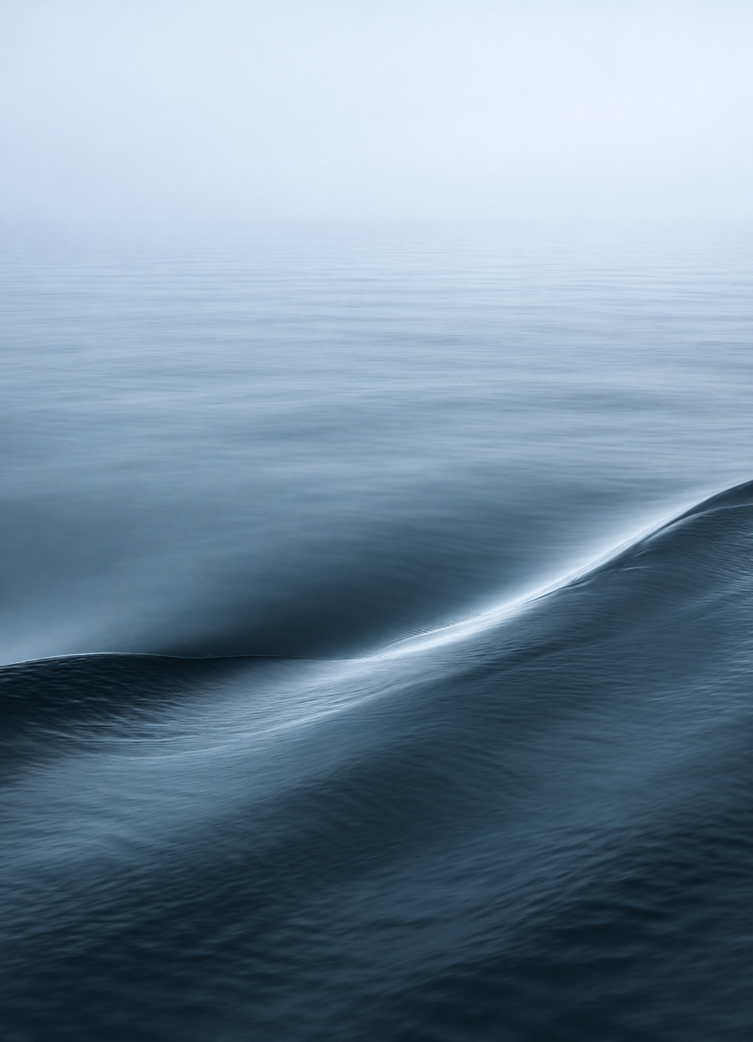 Soft ocean waves beneath a hazy sky, reflecting the sense of balance, stability, and resilience behind Keel Form.