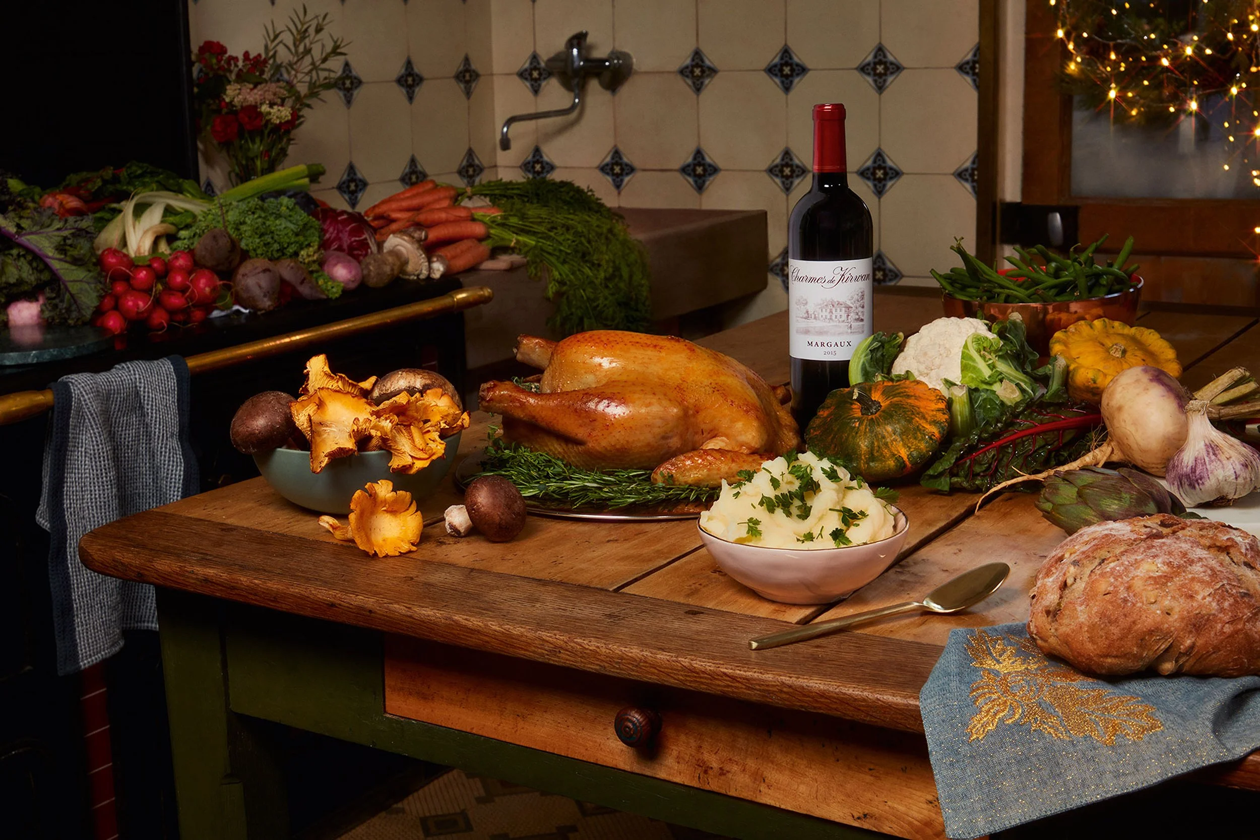 Festive holiday dinner spread with roast goose, mashed potatoes, vegetables, mushrooms, Bordeaux wine, and artisan bread on a rustic table.
