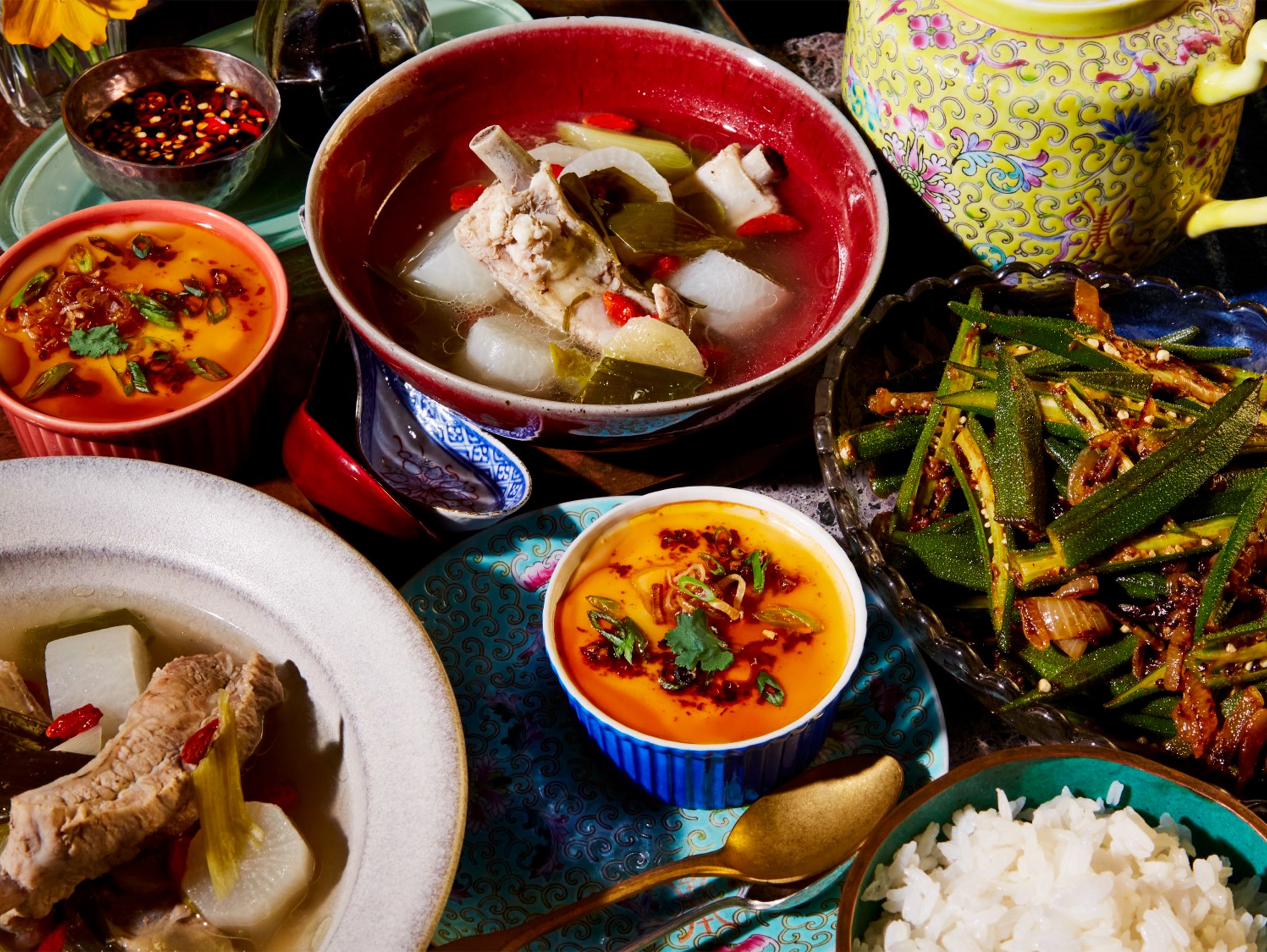 Vietnamese-style family meal with pork and daikon soup, chili dipping sauces, stir-fried okra, and white rice