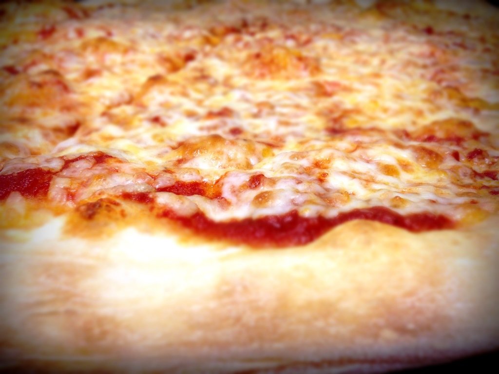 Close-up of a cheesy pepperoni pizza showing melted cheese and tomato sauce.