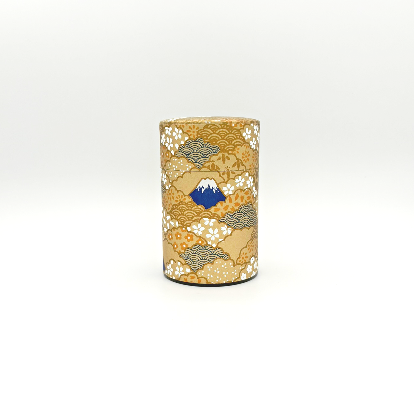 A cylindrical decorated box with traditional Japanese patterns and a mountain design on the front.