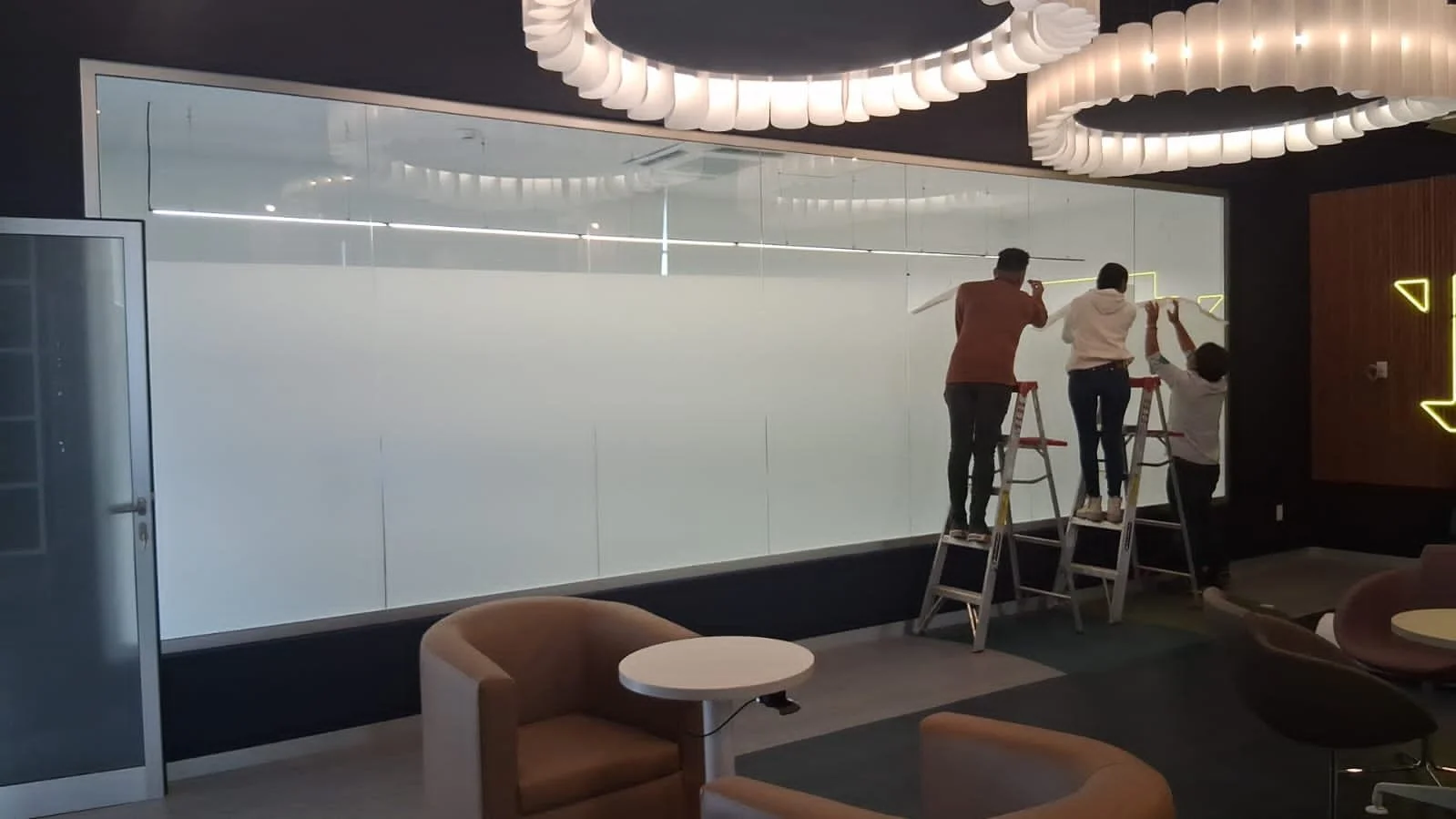 personal trabajando en la instalación de un smart film pdlc en sala de juntas.
