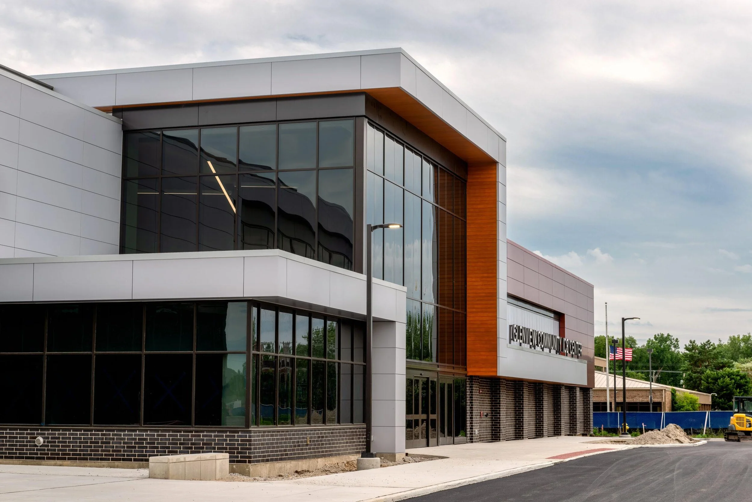 Modern community center building with large glass windows, white and wood exterior panels, and the sign 'Glenview Community Center' on the front.
