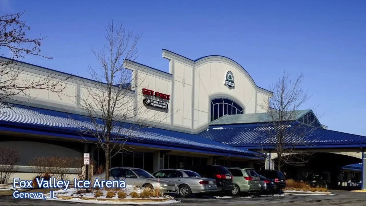 Exterior view of Fox Valley Ice Arena in Geneva, Illinois, with cars parked in front and leafless trees, under a clear blue sky.