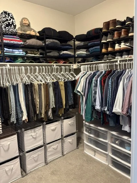 Organized walk-in closet with clothing racks, folded clothes, shoes, storage bins, and drawers