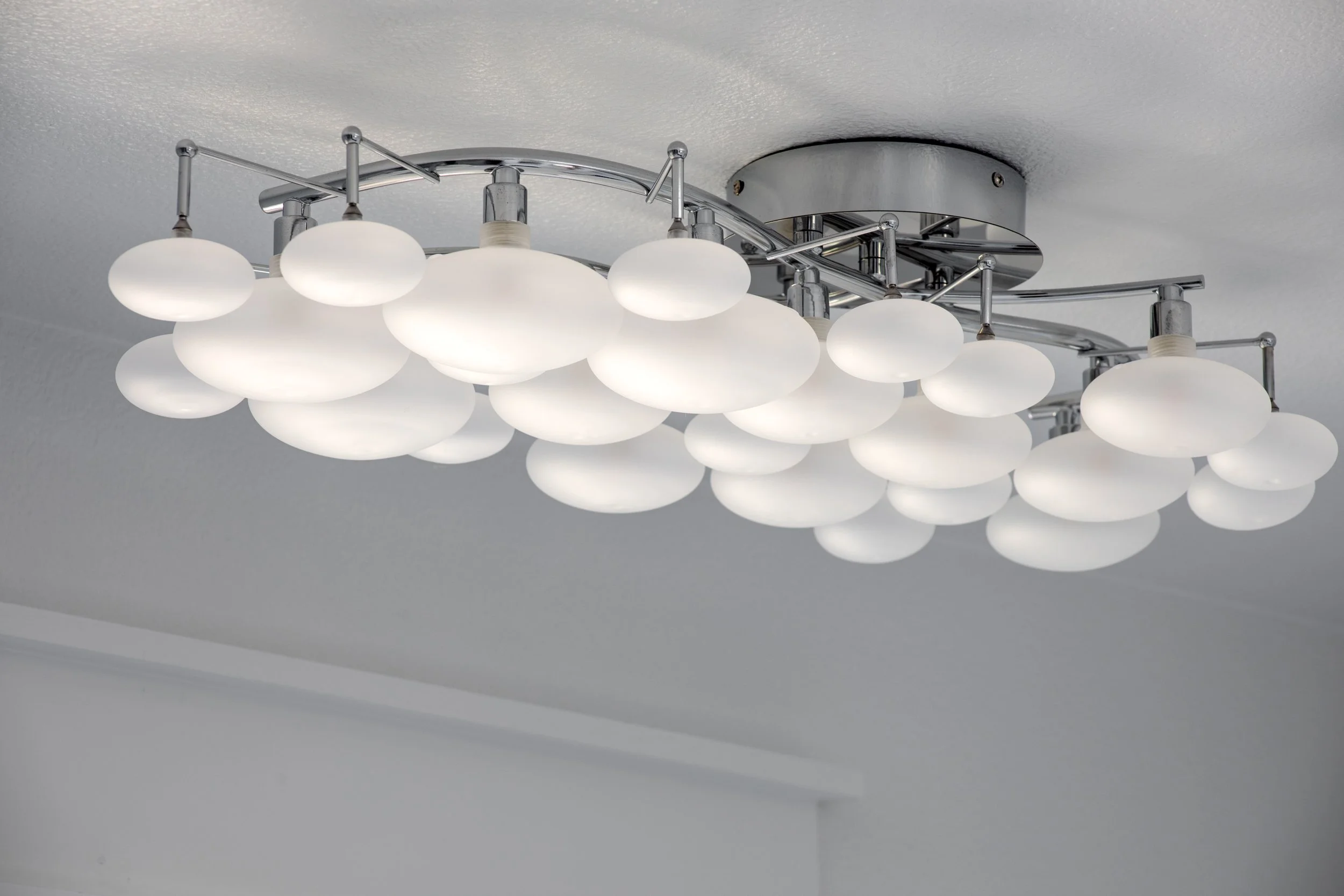 Modern ceiling light fixture with multiple frosted glass globes arranged in rows.