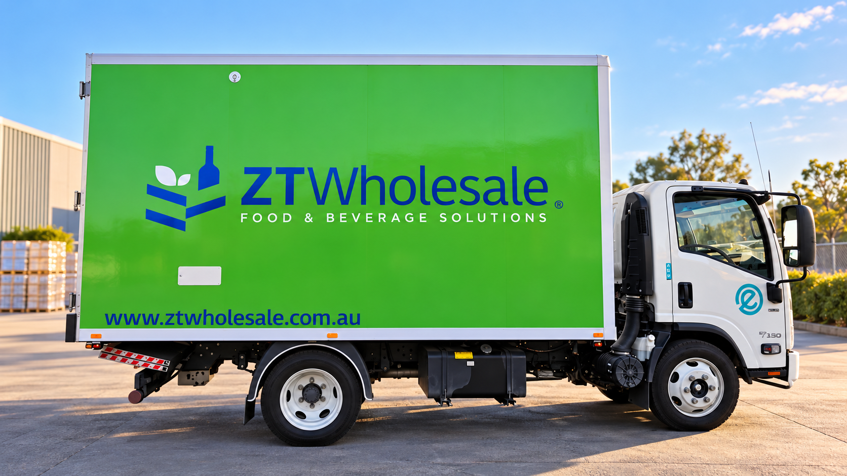 A delivery truck with a green side panel displaying the ZT Wholesale logo, website, and the words Food & Beverage Solutions, parked on a concrete surface outdoors.
