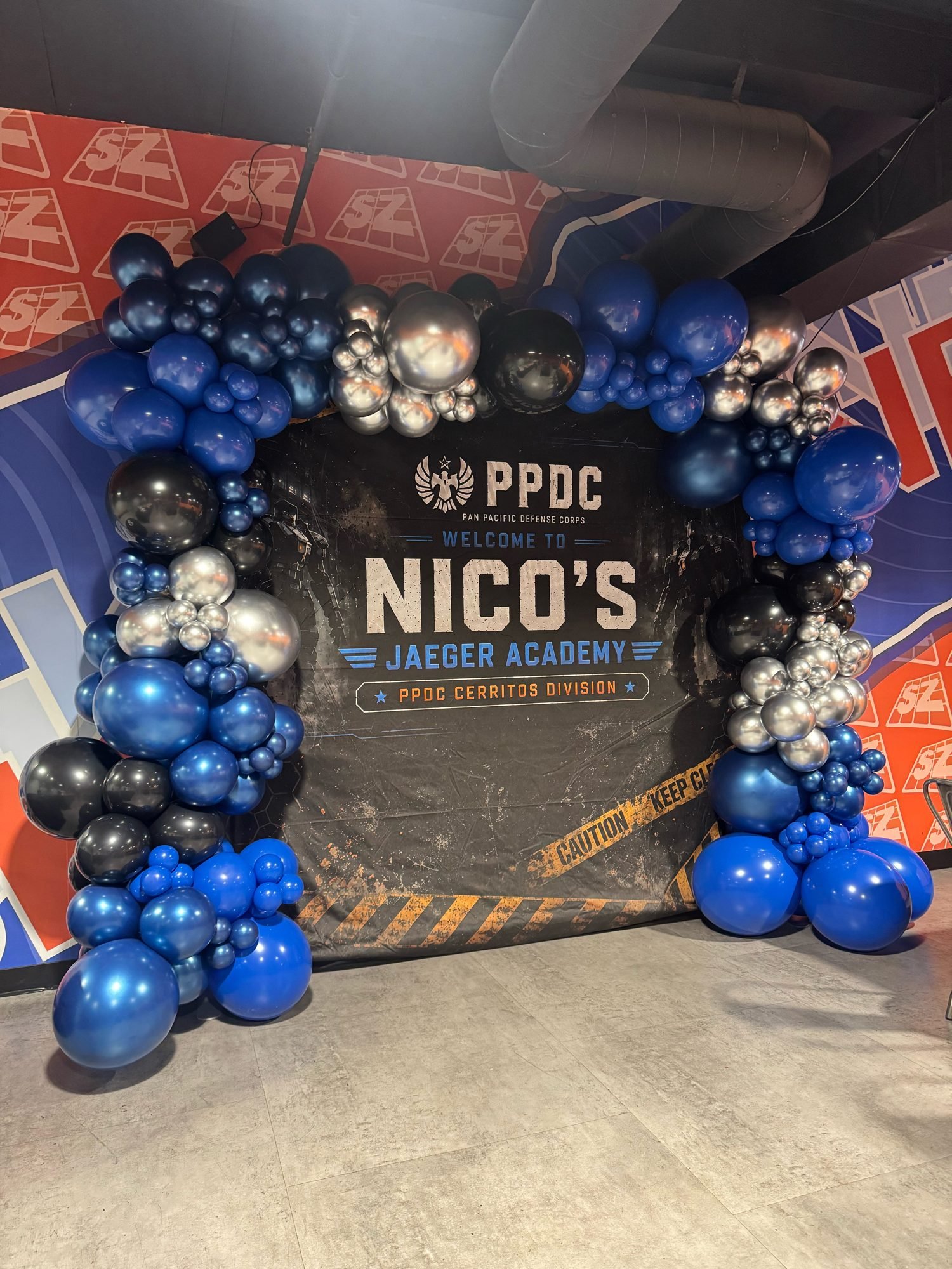 Blue and chrome balloon backdrop for an academy celebration