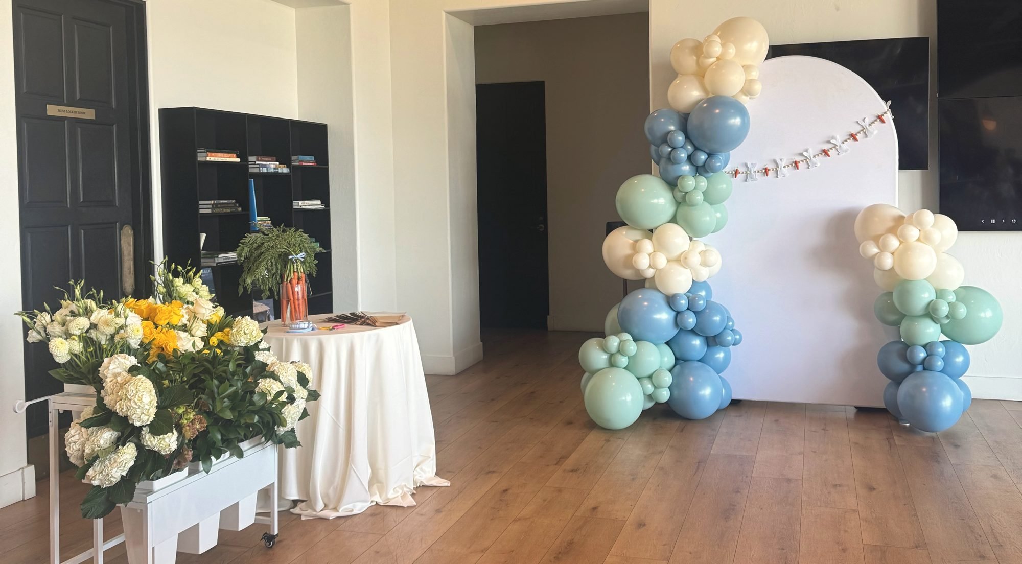 Sage, blue and cream balloon garland on an arch backdrop