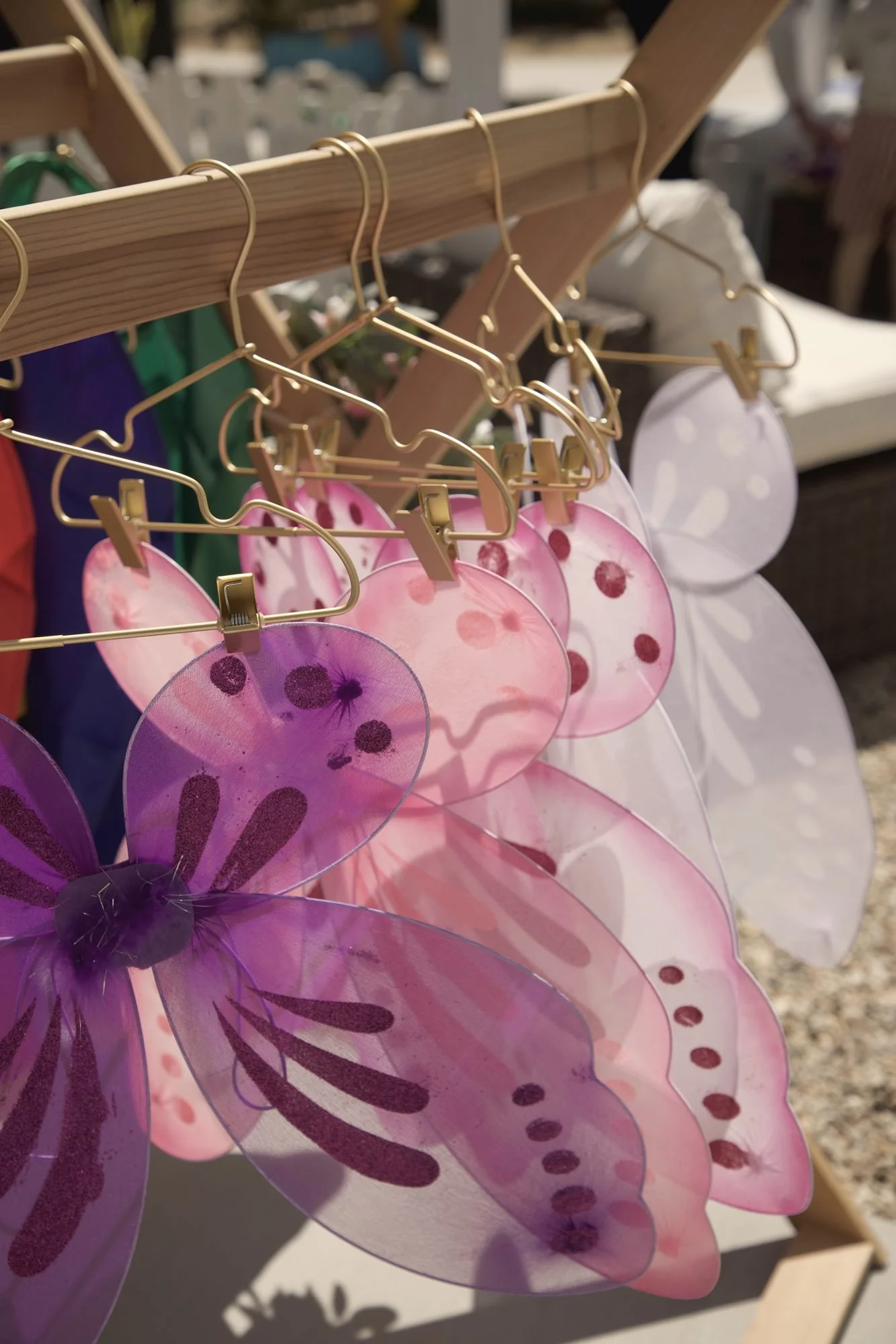 Fairy wings hanging on gold hangers for a kids' party