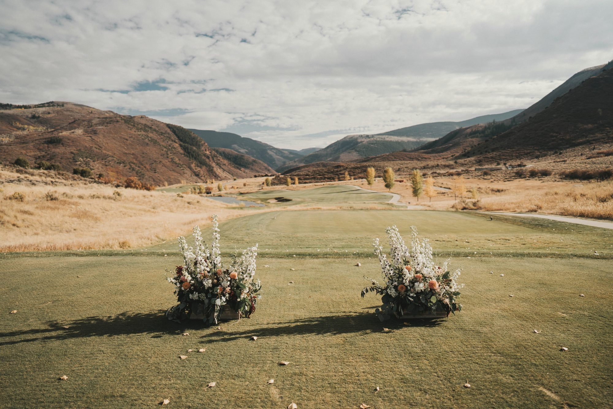 Two ceremony floral arrangements framing a mountain valley view