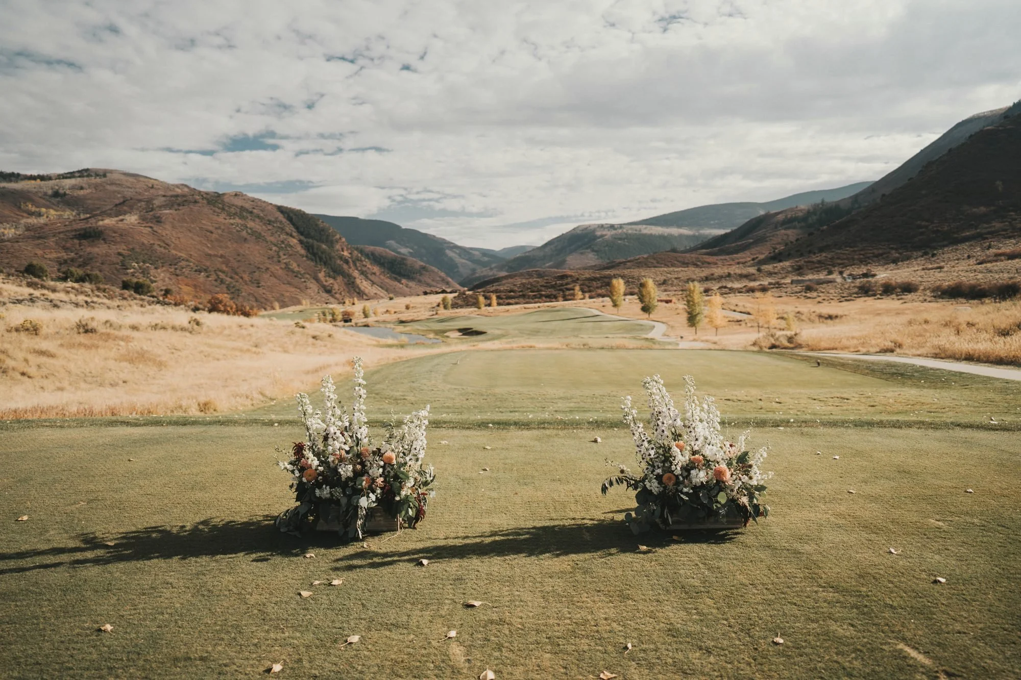 Two ceremony floral arrangements framing a mountain valley view