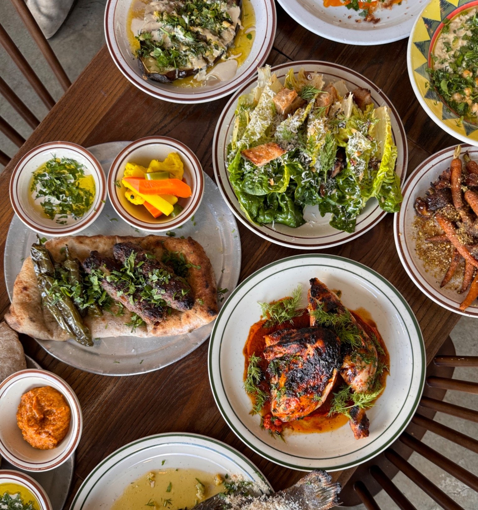 Family-style catering spread with roast chicken, salads, and seasonal sides