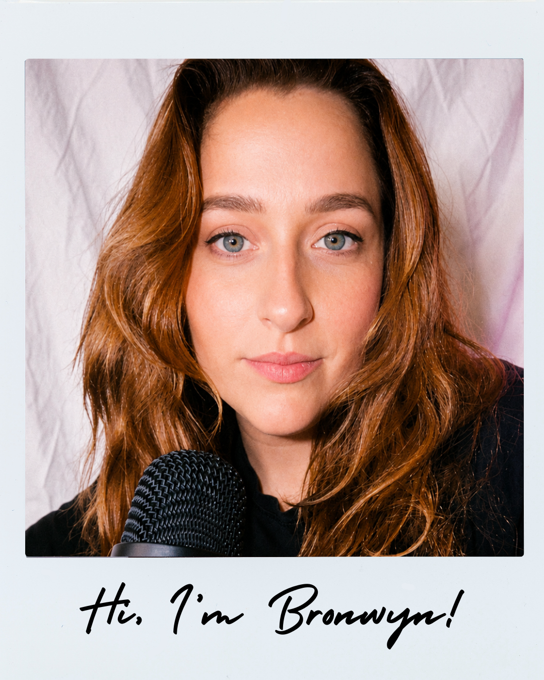 Close-up portrait of a copper-haired woman speaking into a microphone, with handwritten text reading “Hi, I’m Bronwyn!”