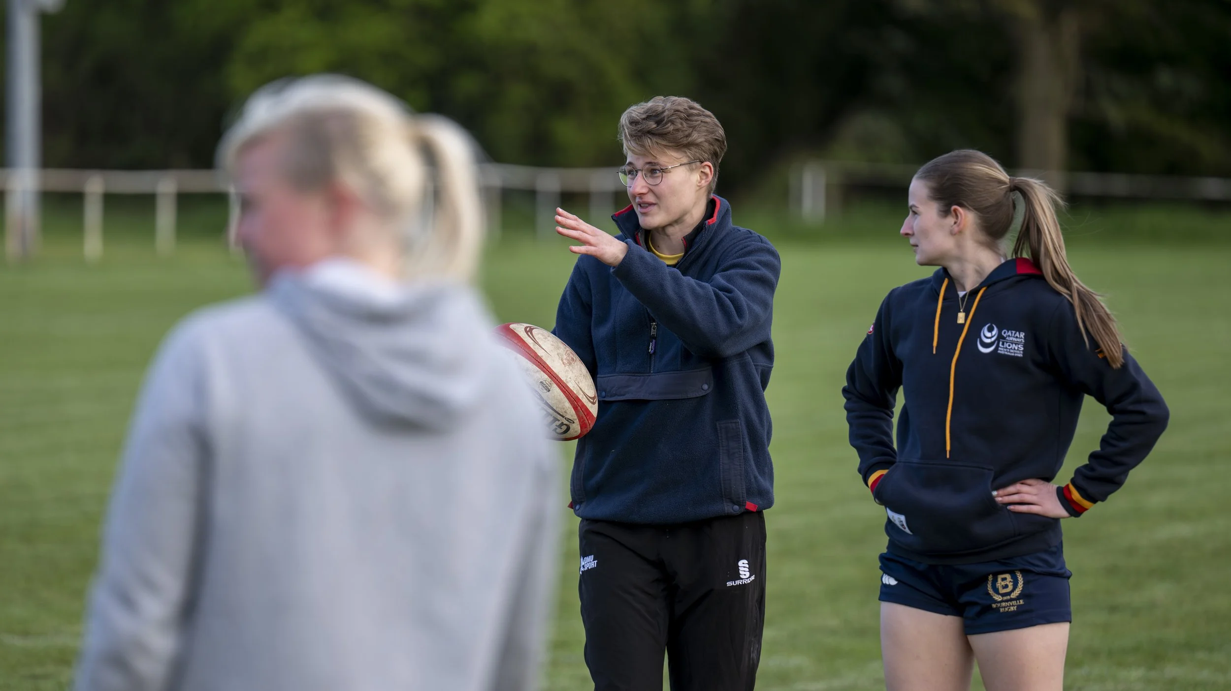 Independent sports mentor Amy Wigley coaching players on a grassy pitch, demonstrating environment design and constraints-led tactics.