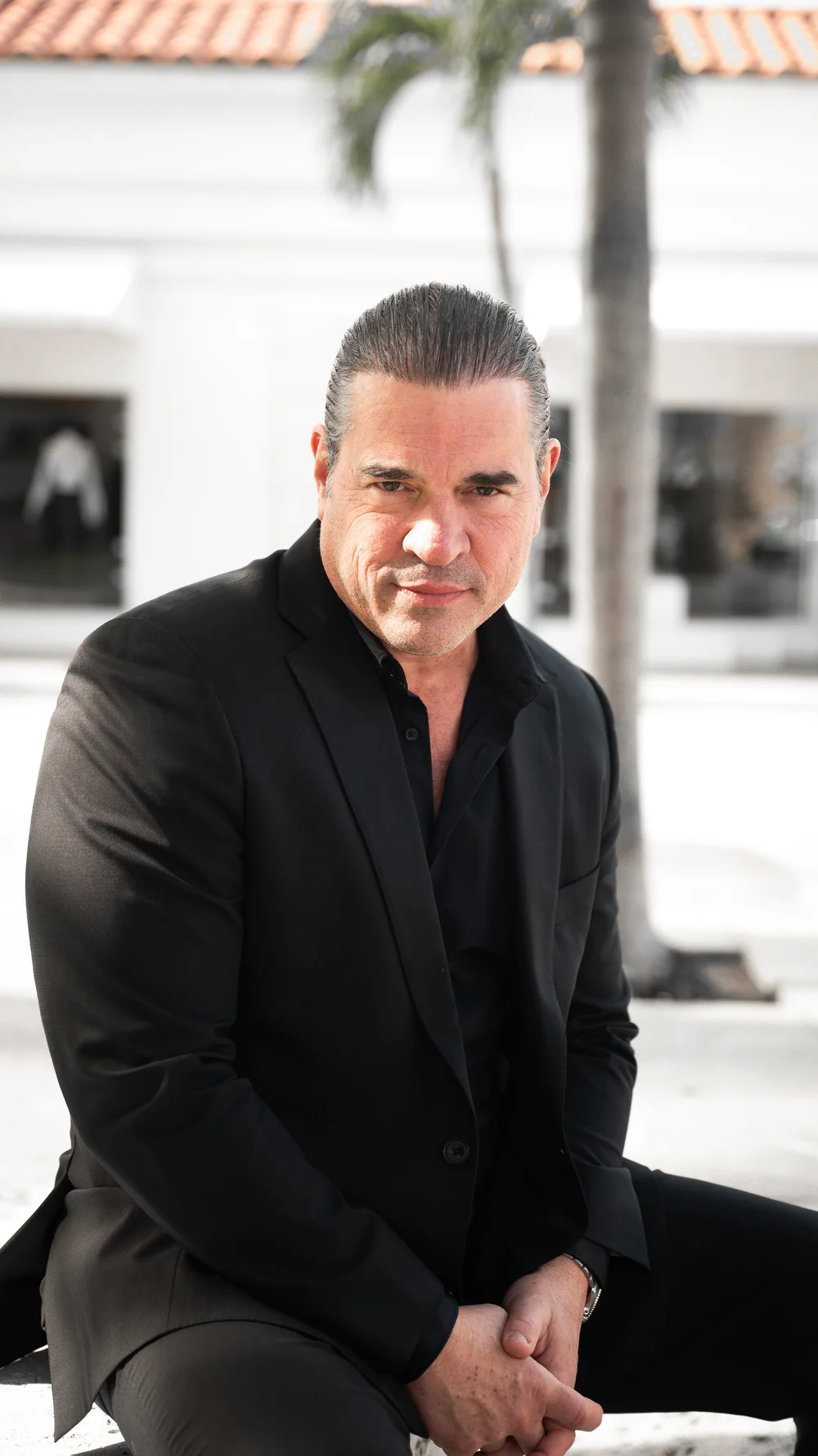 Dr. Christopher Ramsey seated outdoors in a suit
