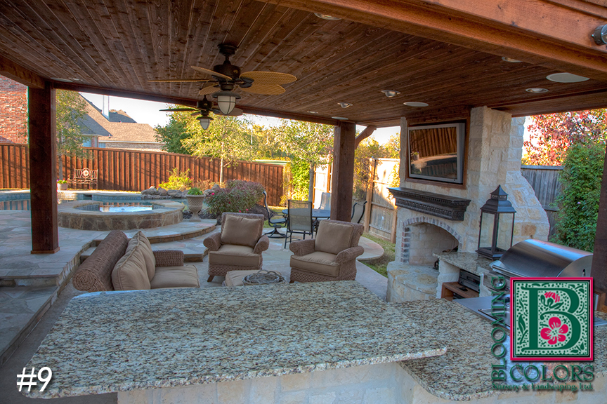 Covered patio with granite counter, ceiling fans and stone fireplace