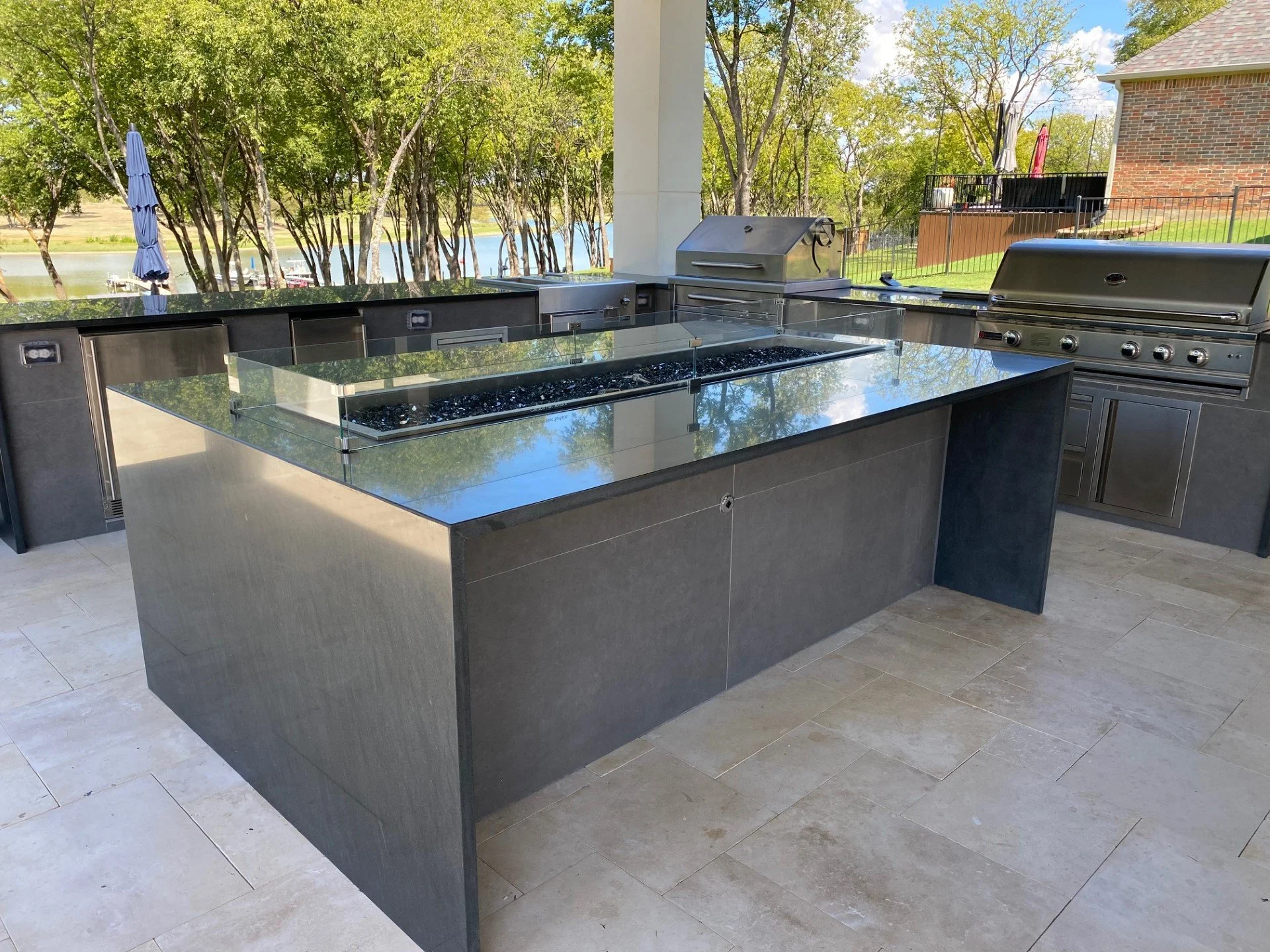 Modern outdoor kitchen island with stainless grill and bar counter