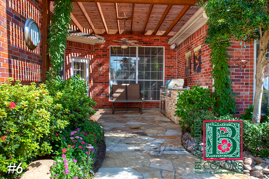 Flagstone patio with outdoor grill and pergola beside a brick home in Grapevine, TX