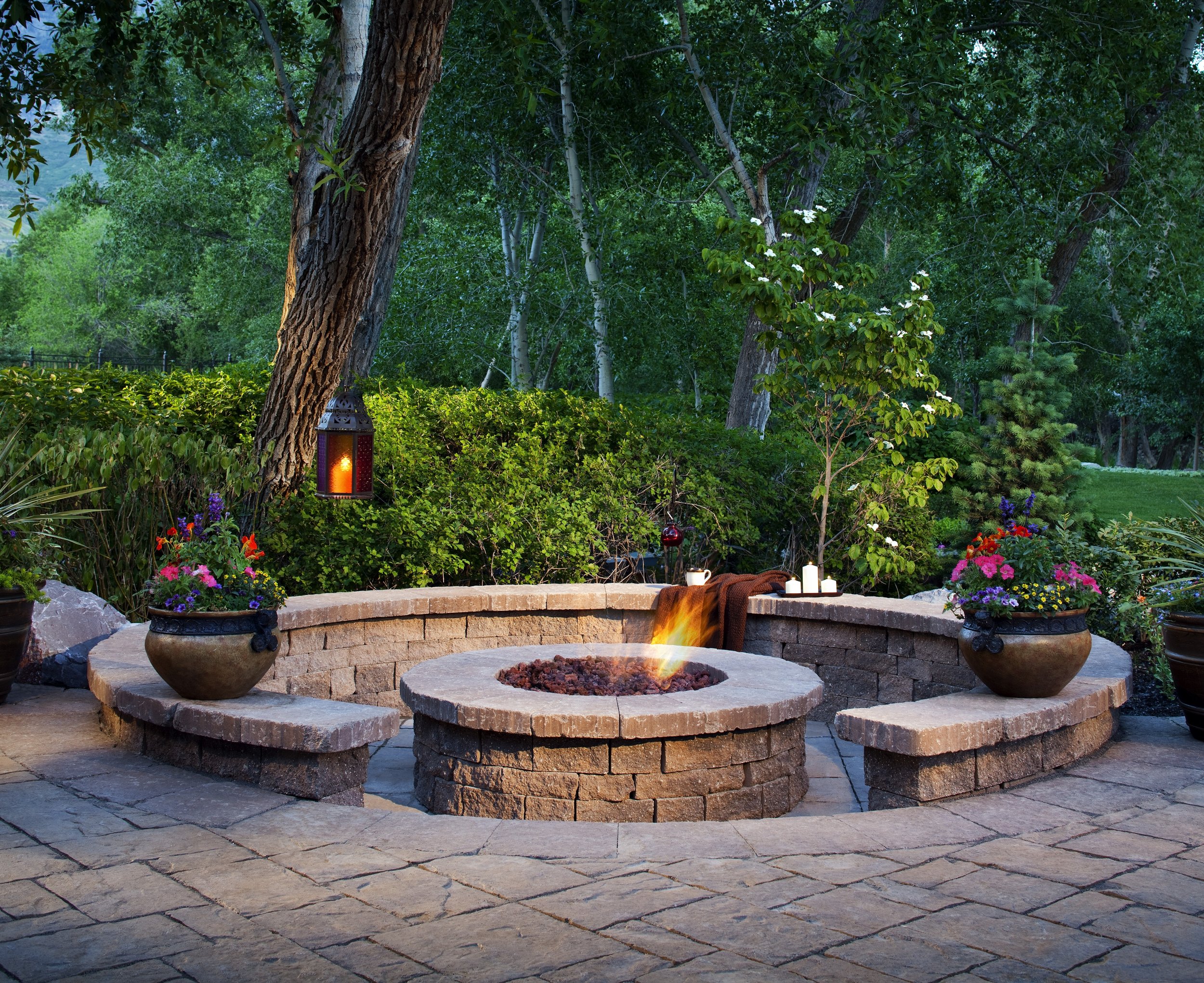 Stone fire pit with seating walls and planters on a patio in Southlake TX