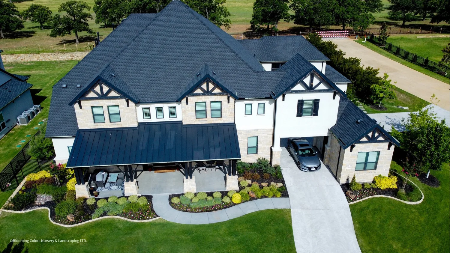 Aerial view of a home with a landscaped front lawn and planting beds