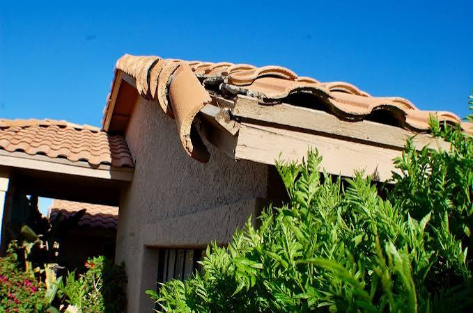 Damaged tile roofing and exposed roof-edge conditions