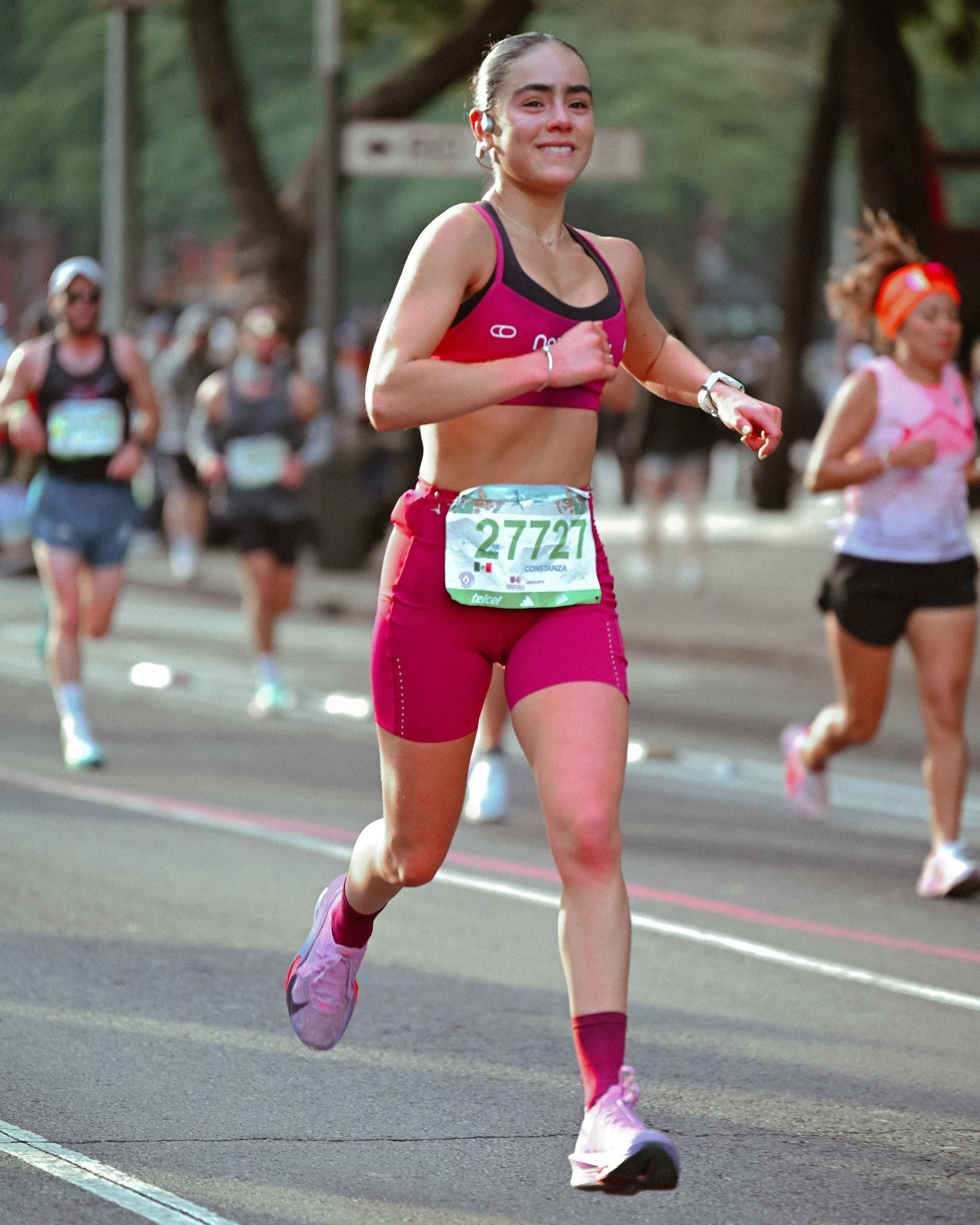 Corredora con conjunto rosa durante una carrera urbana.