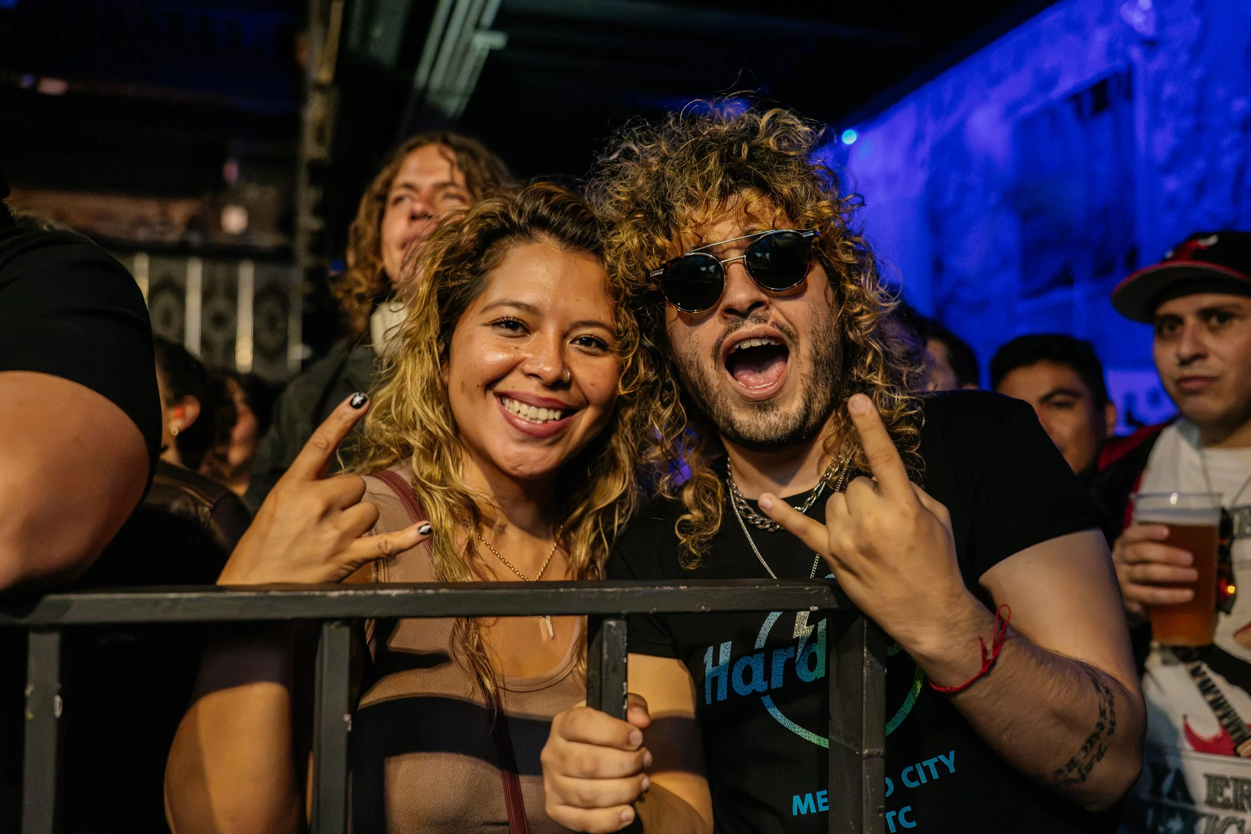 Retrato de dos asistentes a un concierto junto al escenario.