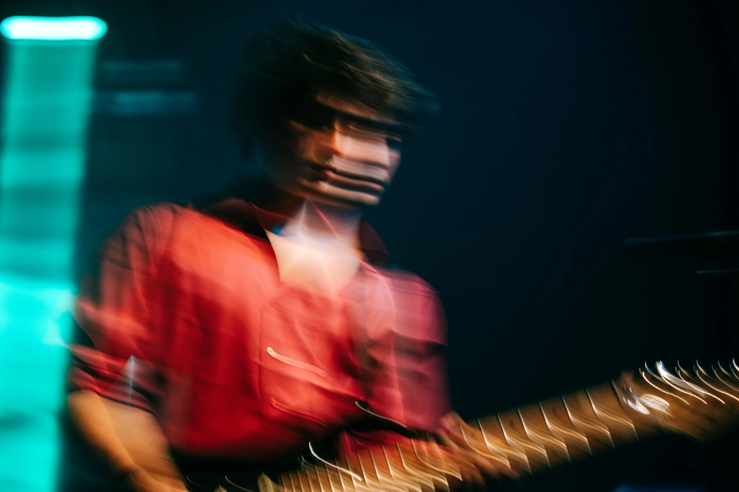 Guitarrista de camisa roja con efecto de barrido.