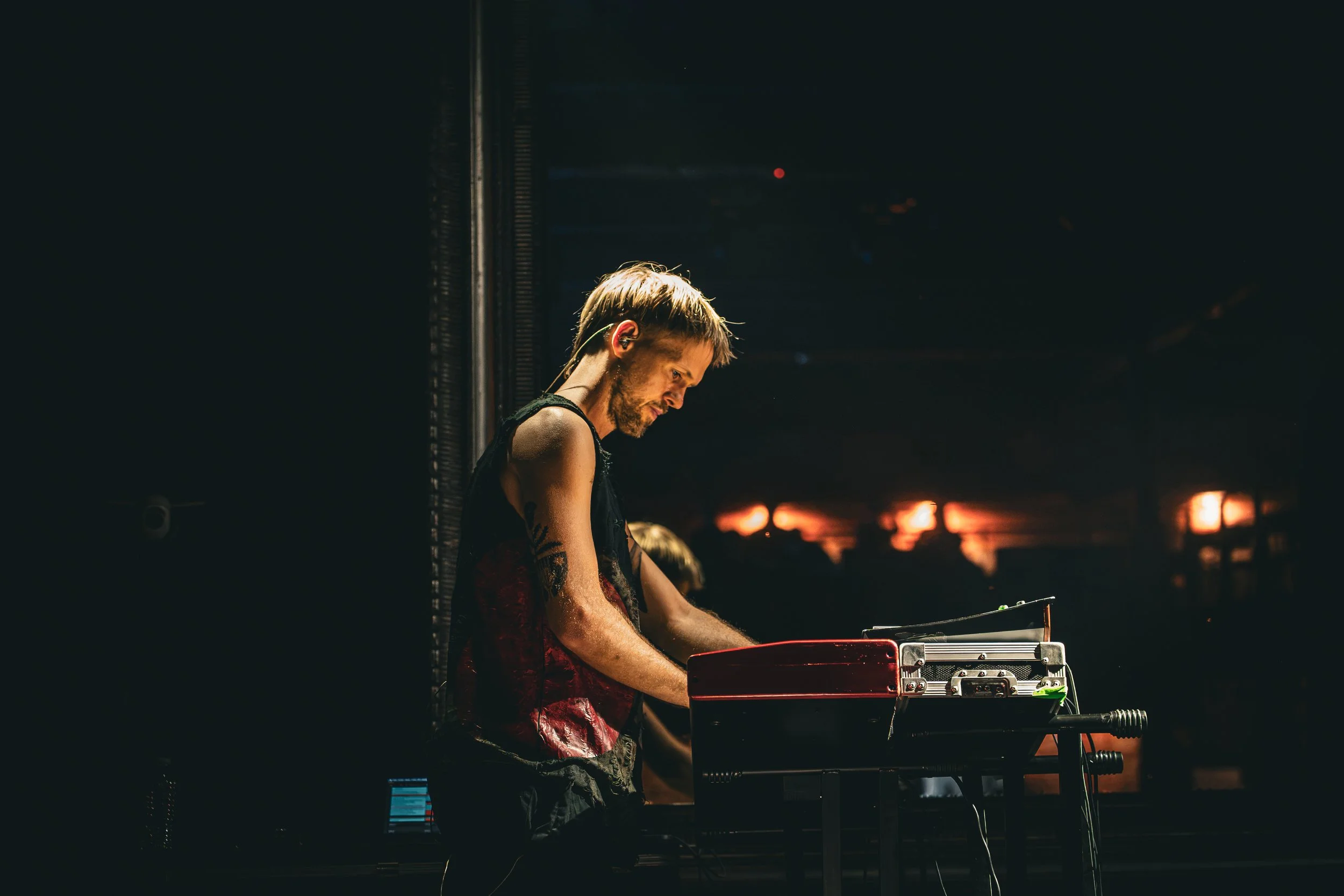 Tecladista de perfil tocando durante una presentación.