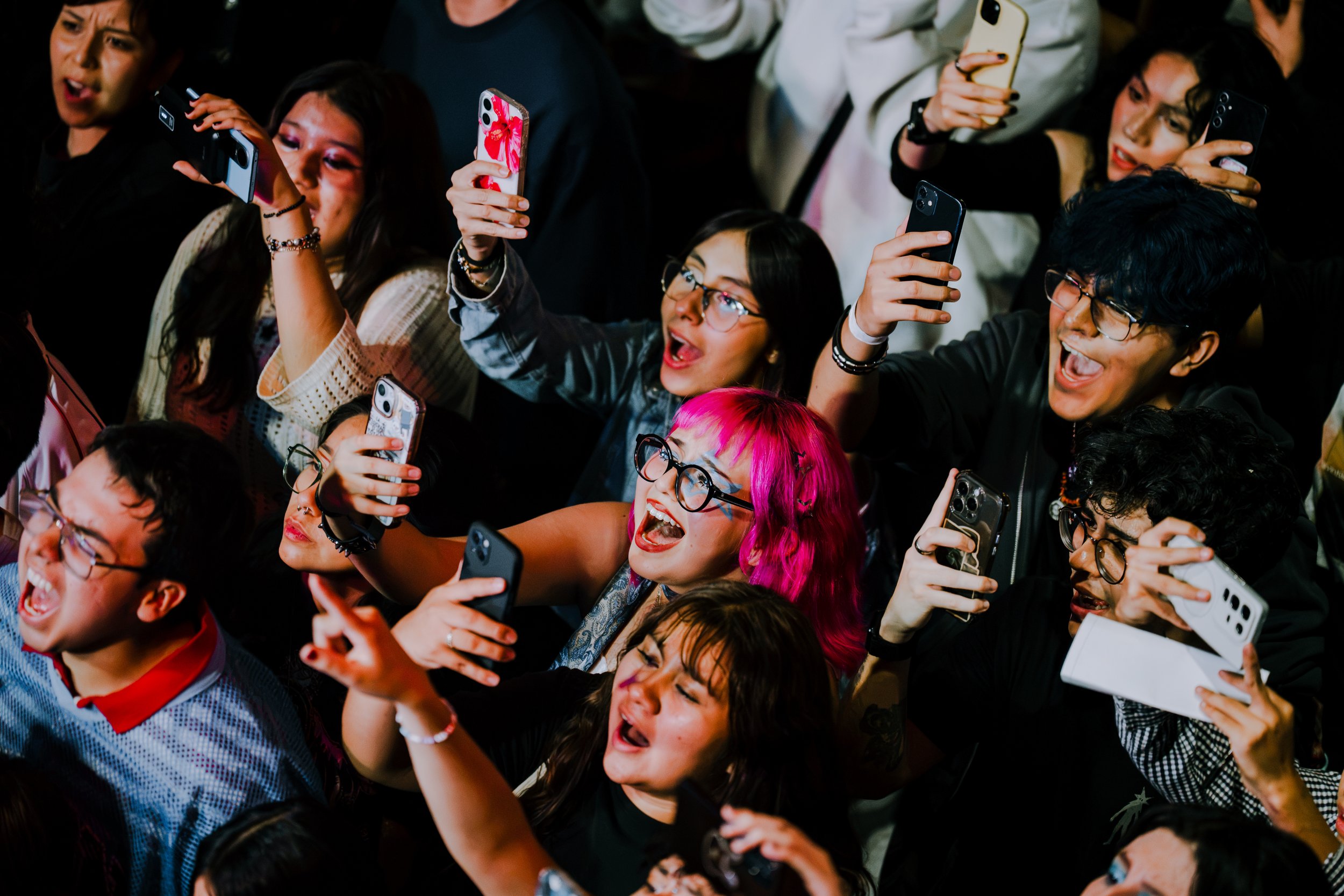 Asistentes junto al escenario mirando hacia los artistas.
