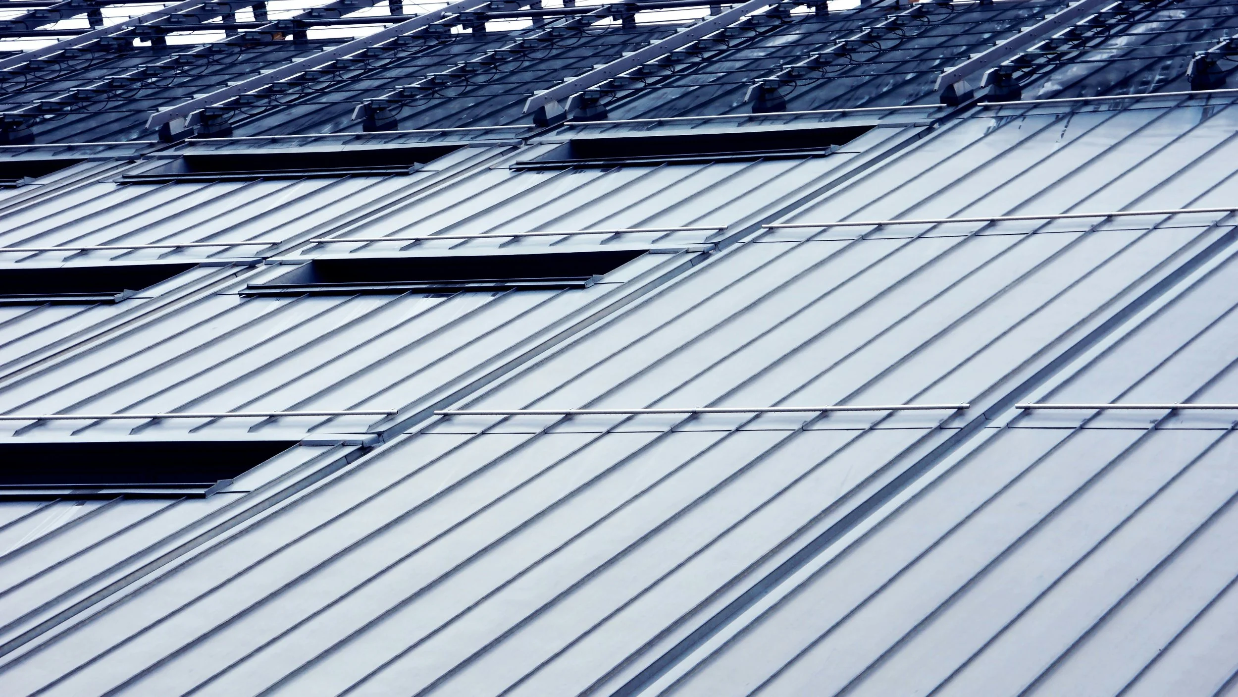 Close-up view of a metallic rooftop with solar panels installed on it.