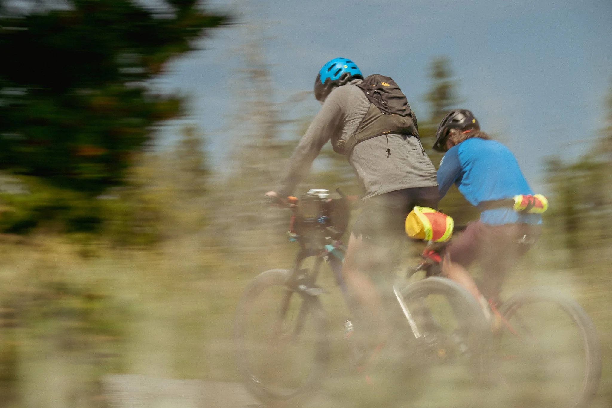 Two bikers biking quickly by 