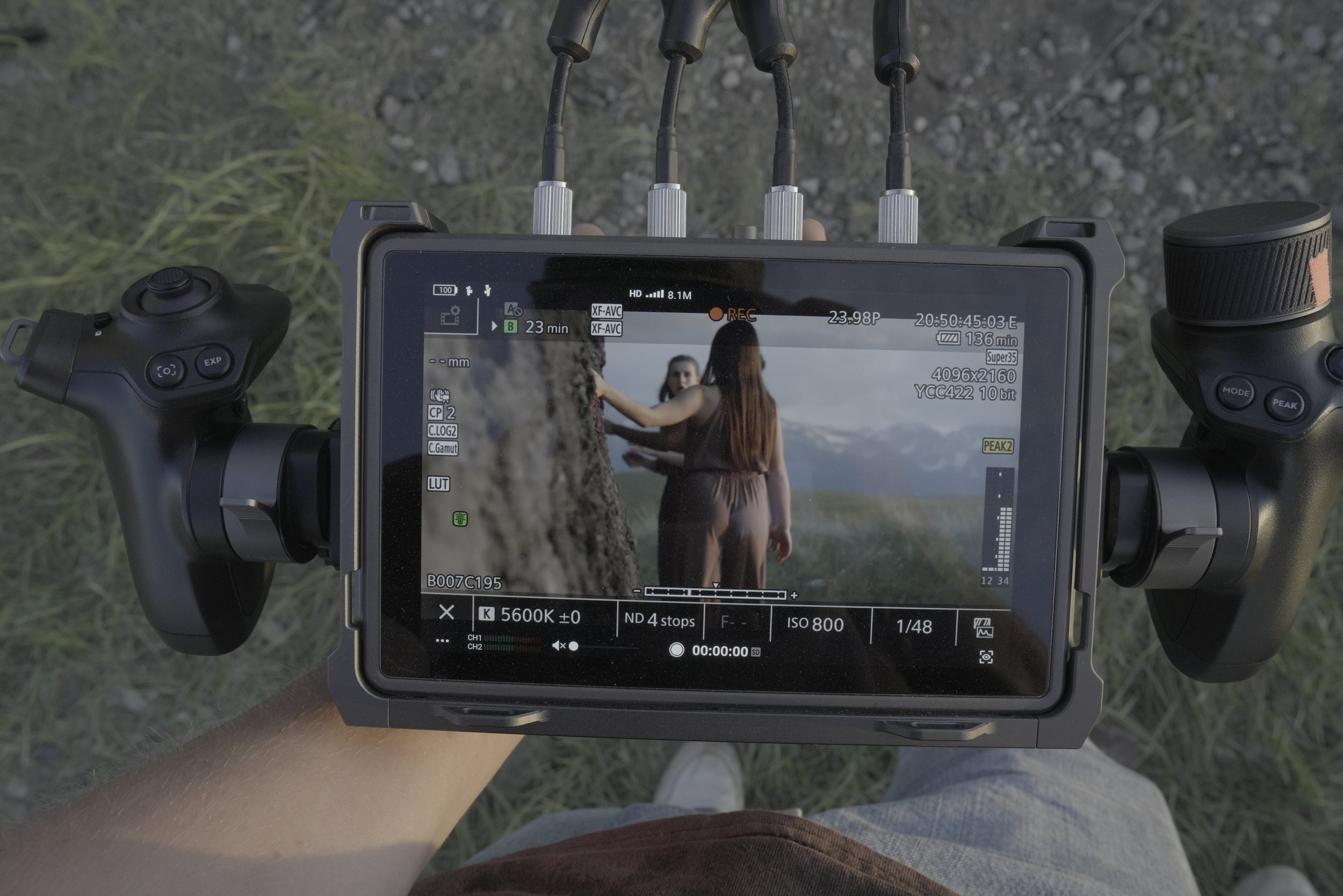 Holding up a directors monitor showing dancers on camera