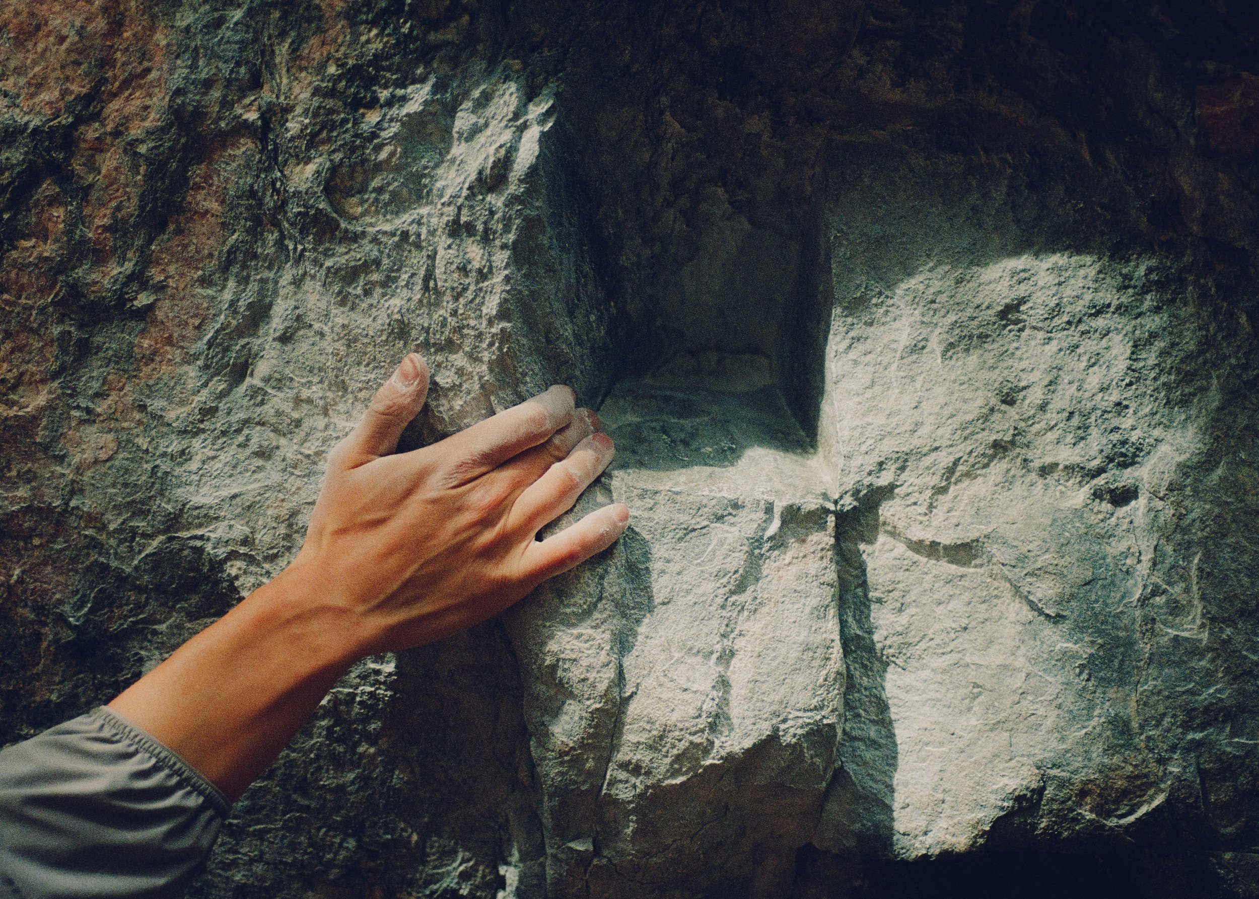 35mm Film Photo of Hand grabbing rock