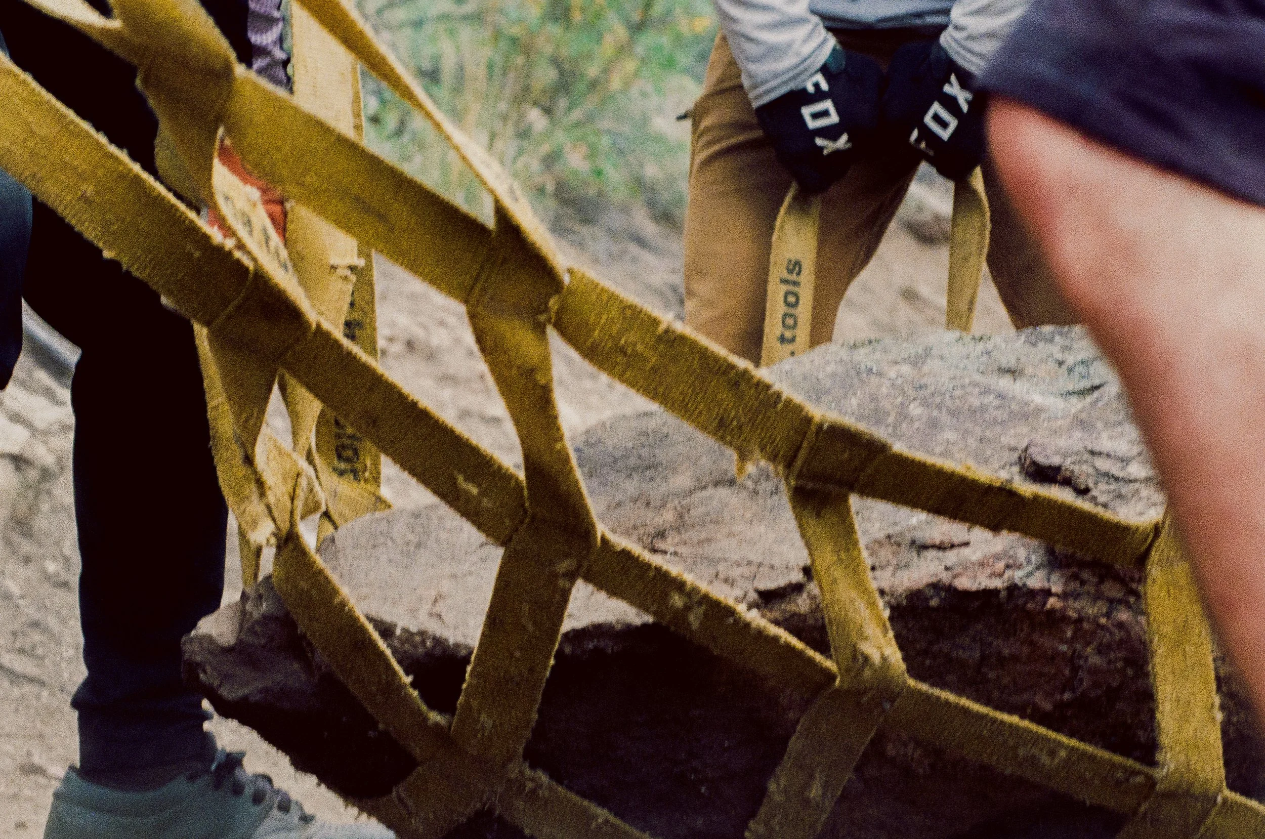 35mm film photo of Mountain Bikers moving a large rock with yellow netting