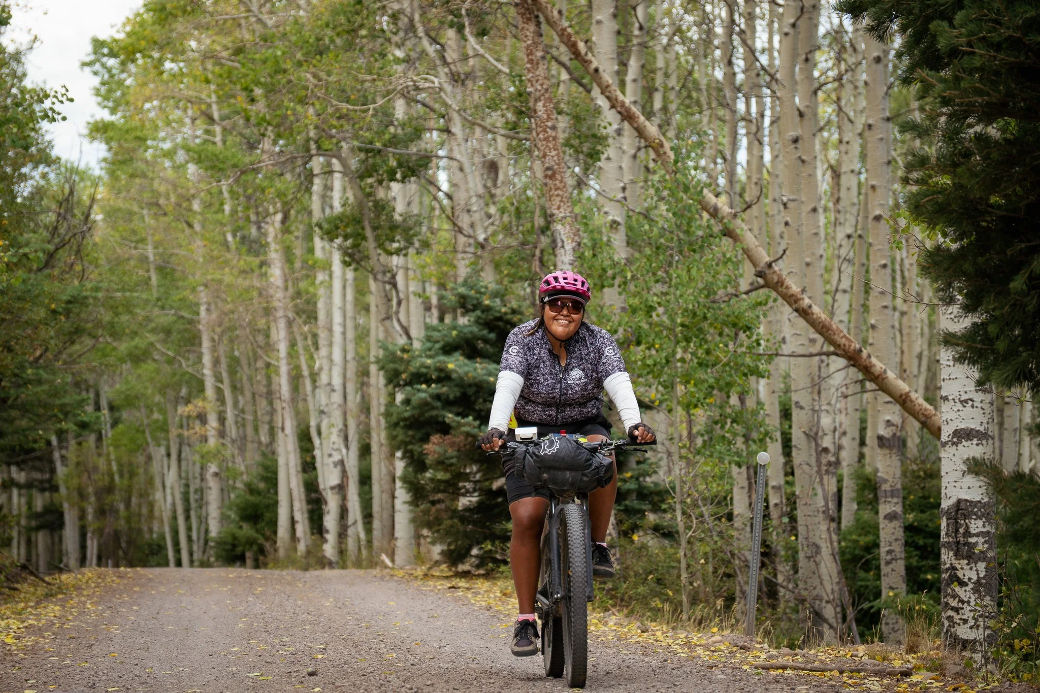 Bike packer smiling as she bikes down the road