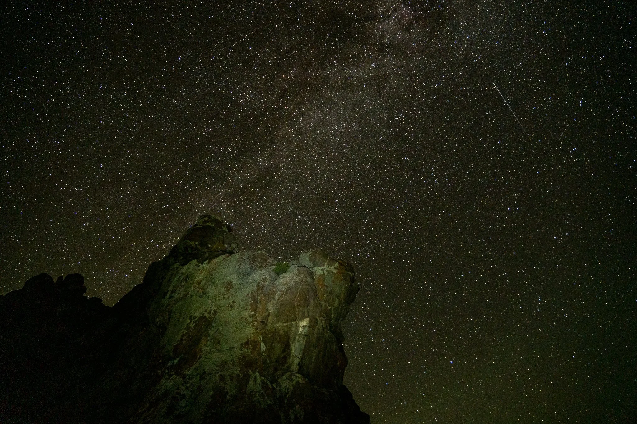 The Milky Way over a large rocky outcropping