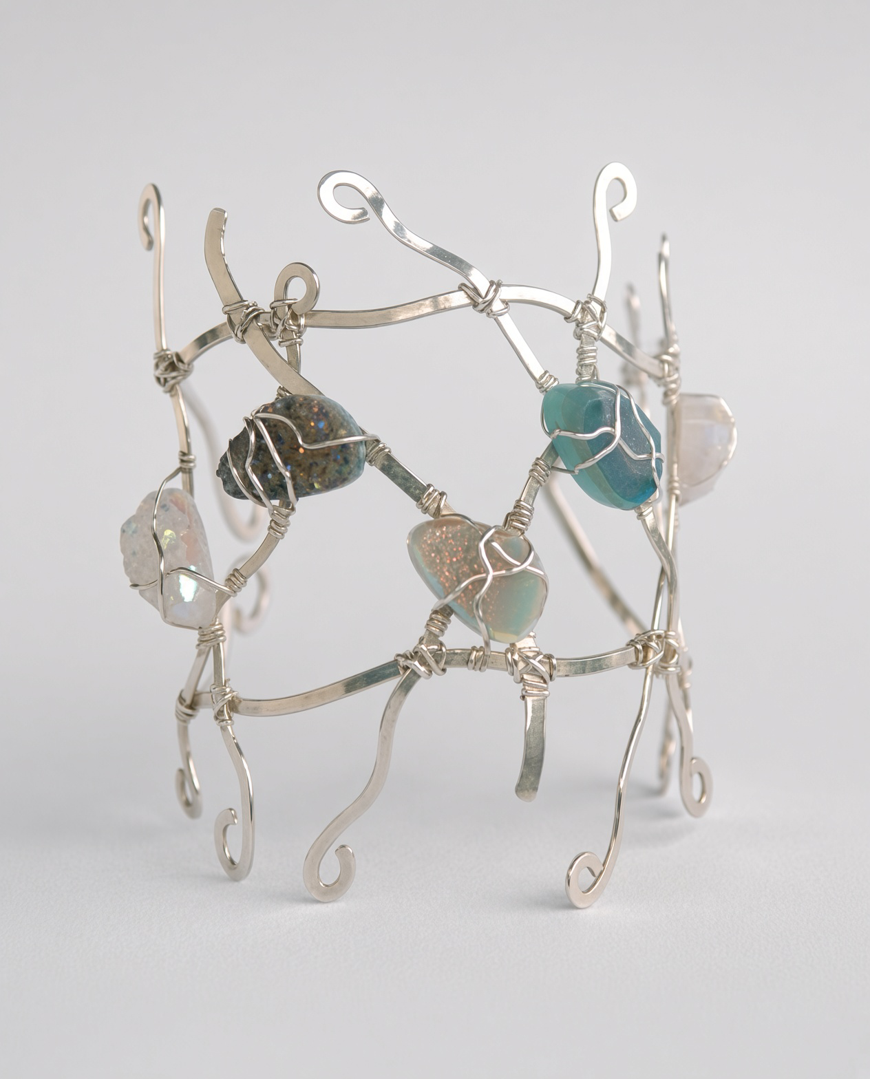 Handcrafted silver wire bracelet featuring colorful polished gemstone beads and curled ends