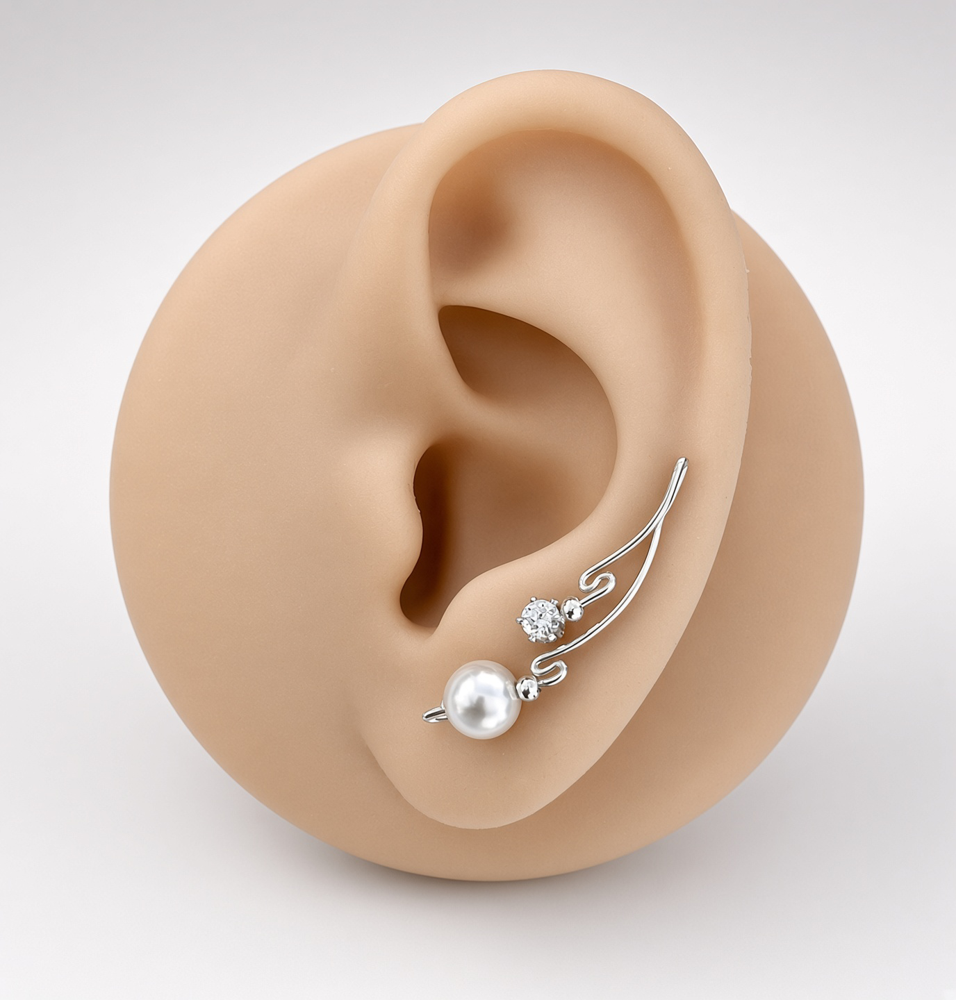 Silver ear climber earring with pearl and crystal accents displayed on a mannequin ear