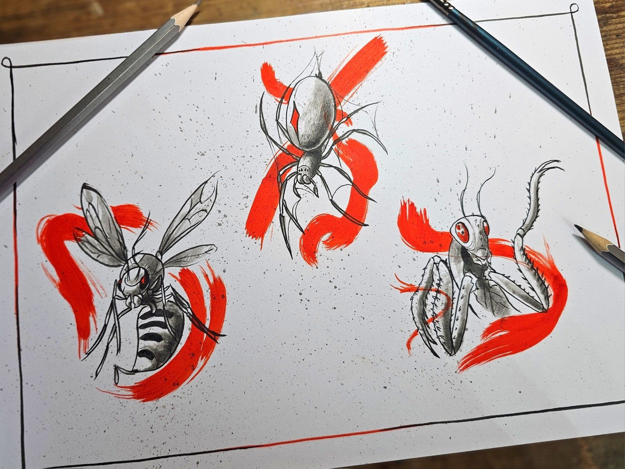 A sheet of paper with a detailed black and white illustration of various insects and arachnids, accents of red paint, and framing lines around the edge, with art supplies like a pencil and a pen on a wooden surface.