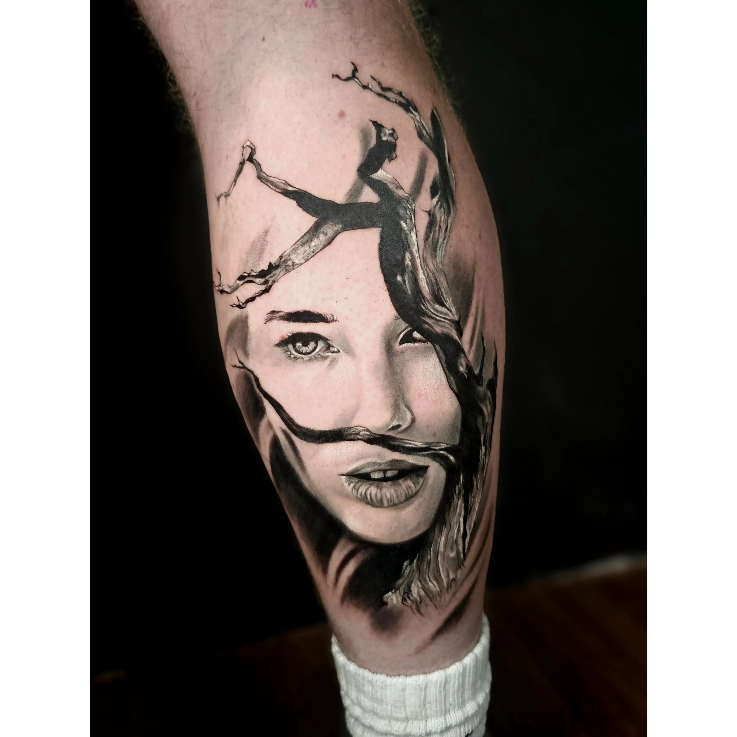 Tattoo of Marilyn Monroe's face on a person's upper arm.