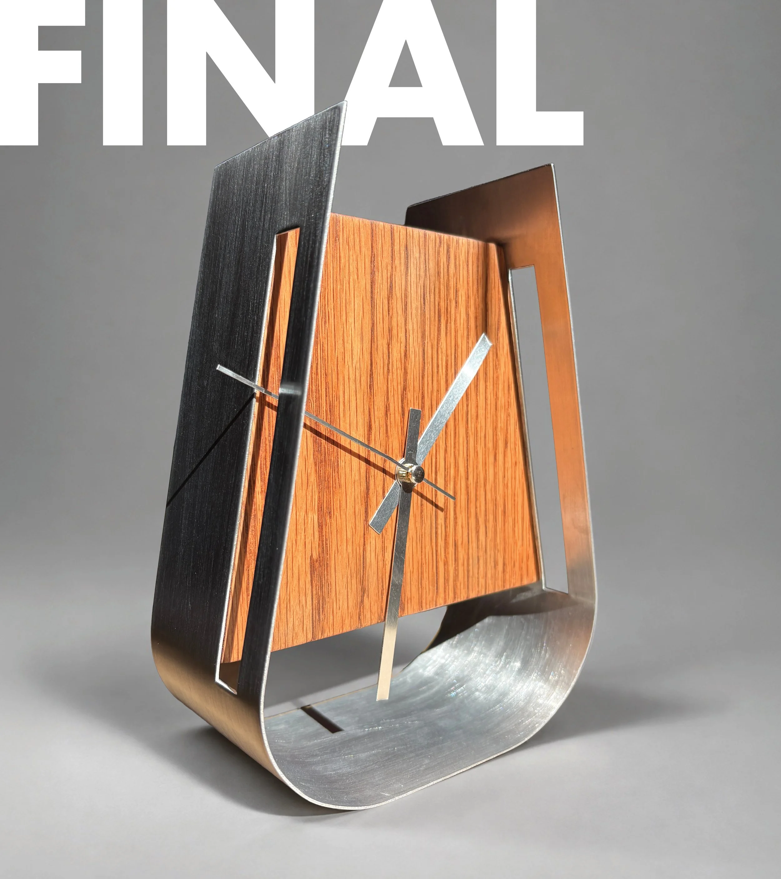 Close-up of a modern clock with a wooden face and metallic black and silver details, against a gray background.