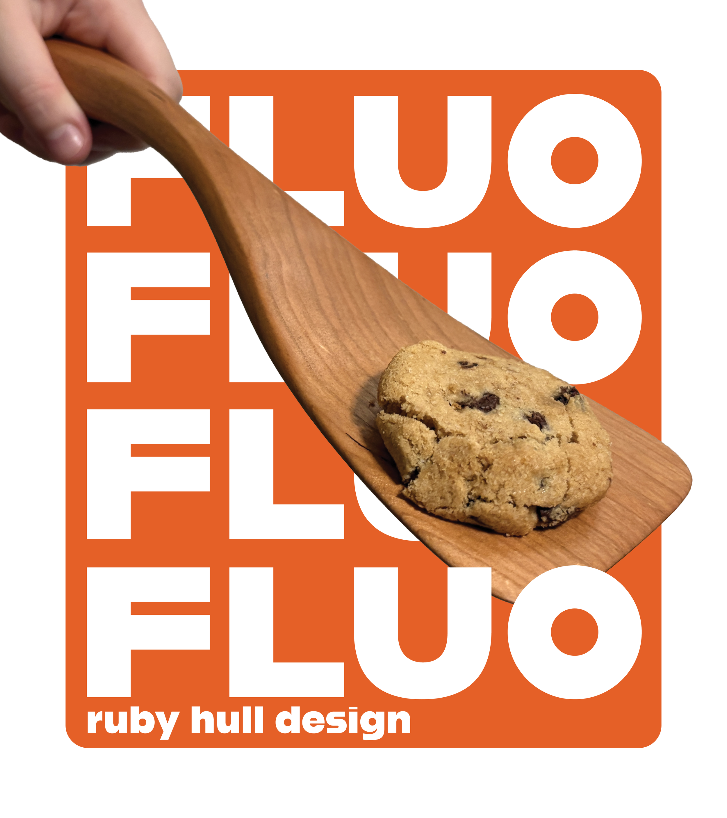 Close-up of a person's hand holding a wooden spatula with a chocolate chip cookie resting on it, against a background with the text "ruby hull design."