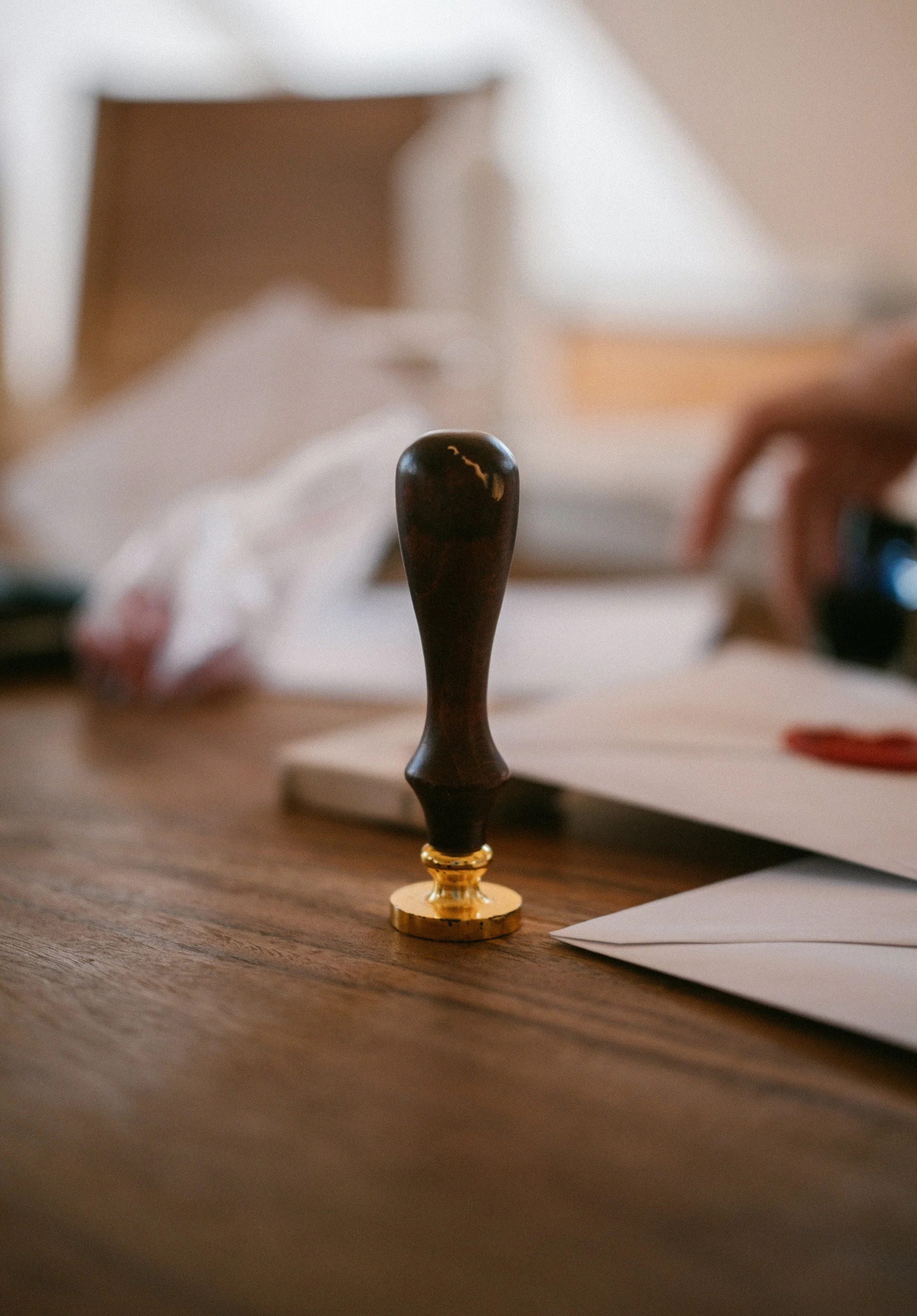 Close-up of a chess piece on a wooden table with blurred papers in the background.