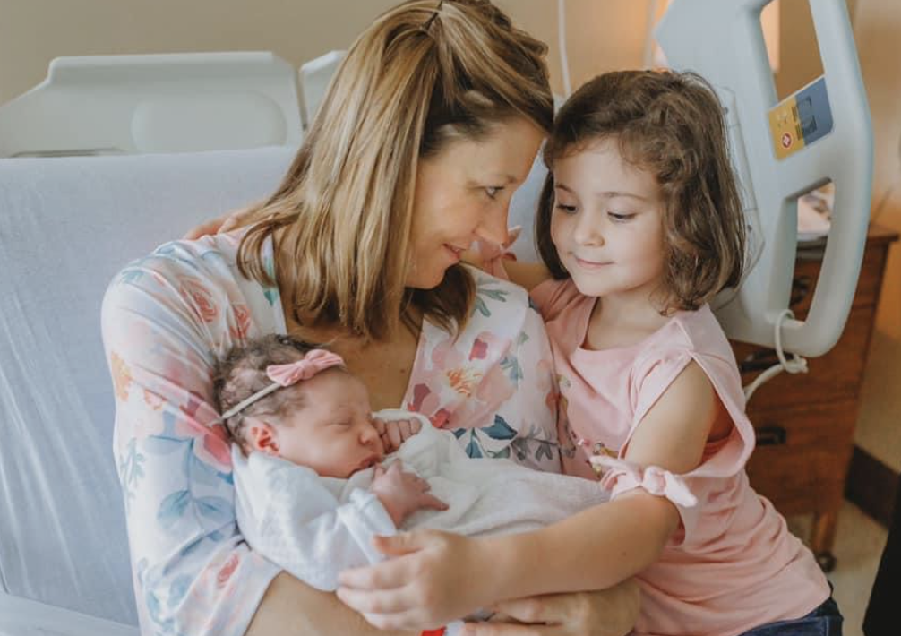 Big sister meeting her newborn sibling in the hospital