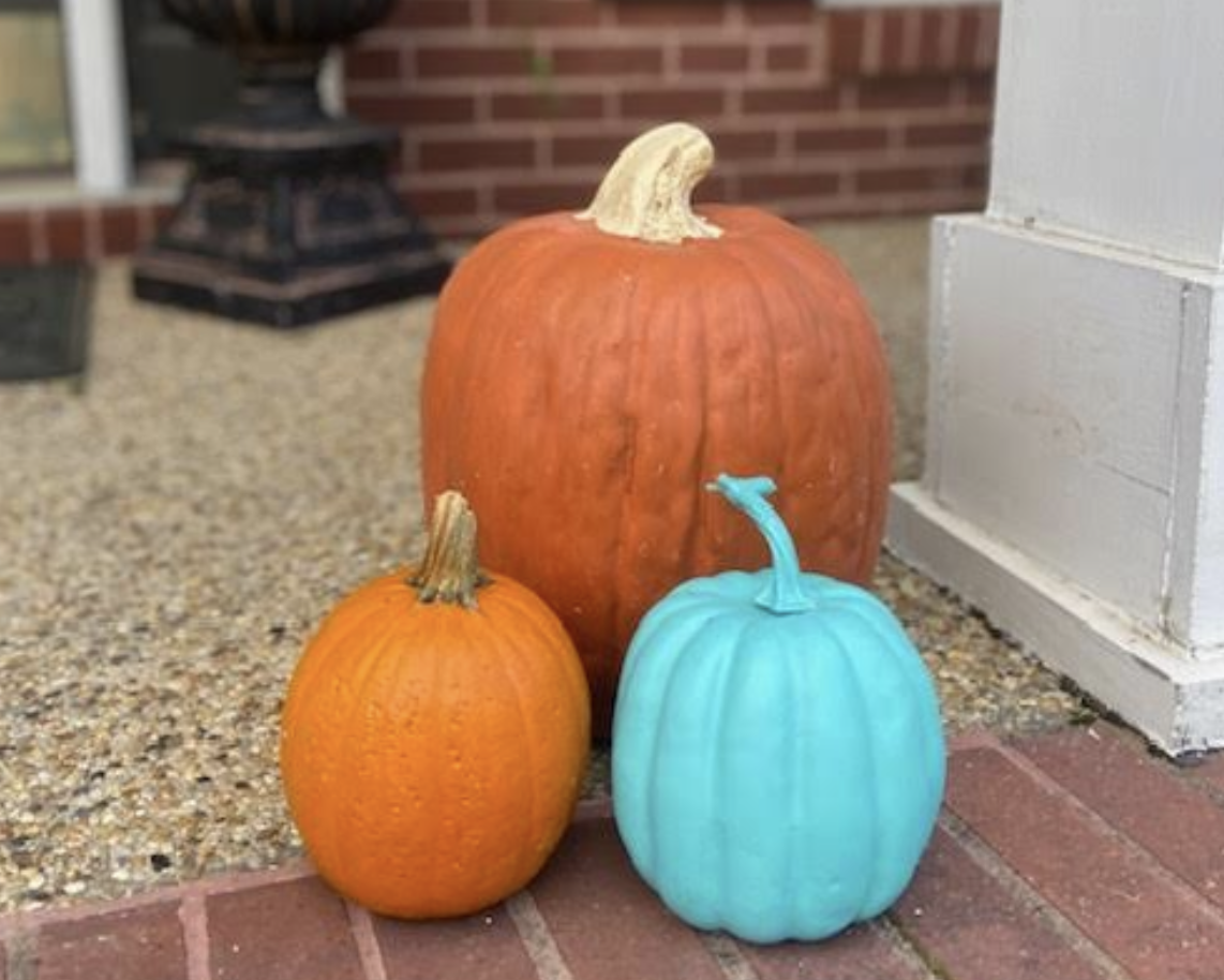 Orange and teal pumpkins on a front porch for the Teal Pumpkin Project